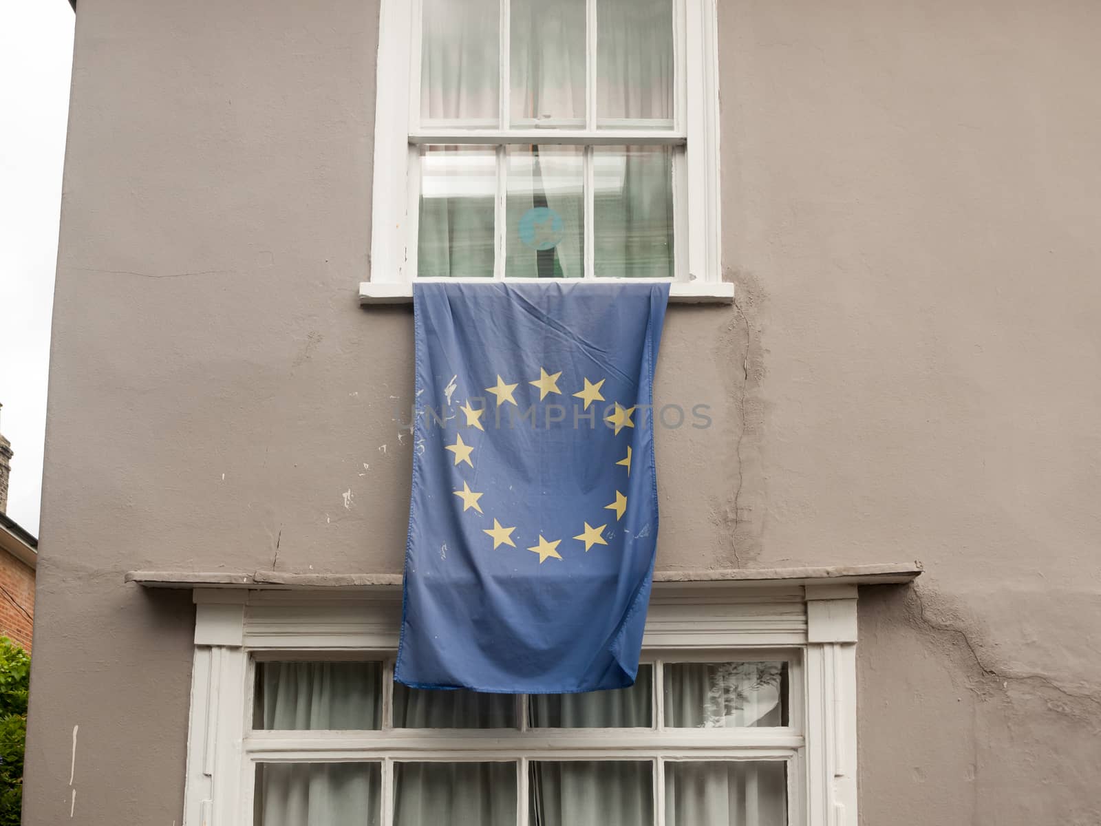 a european flag draped outside of a window; Essex; UK
