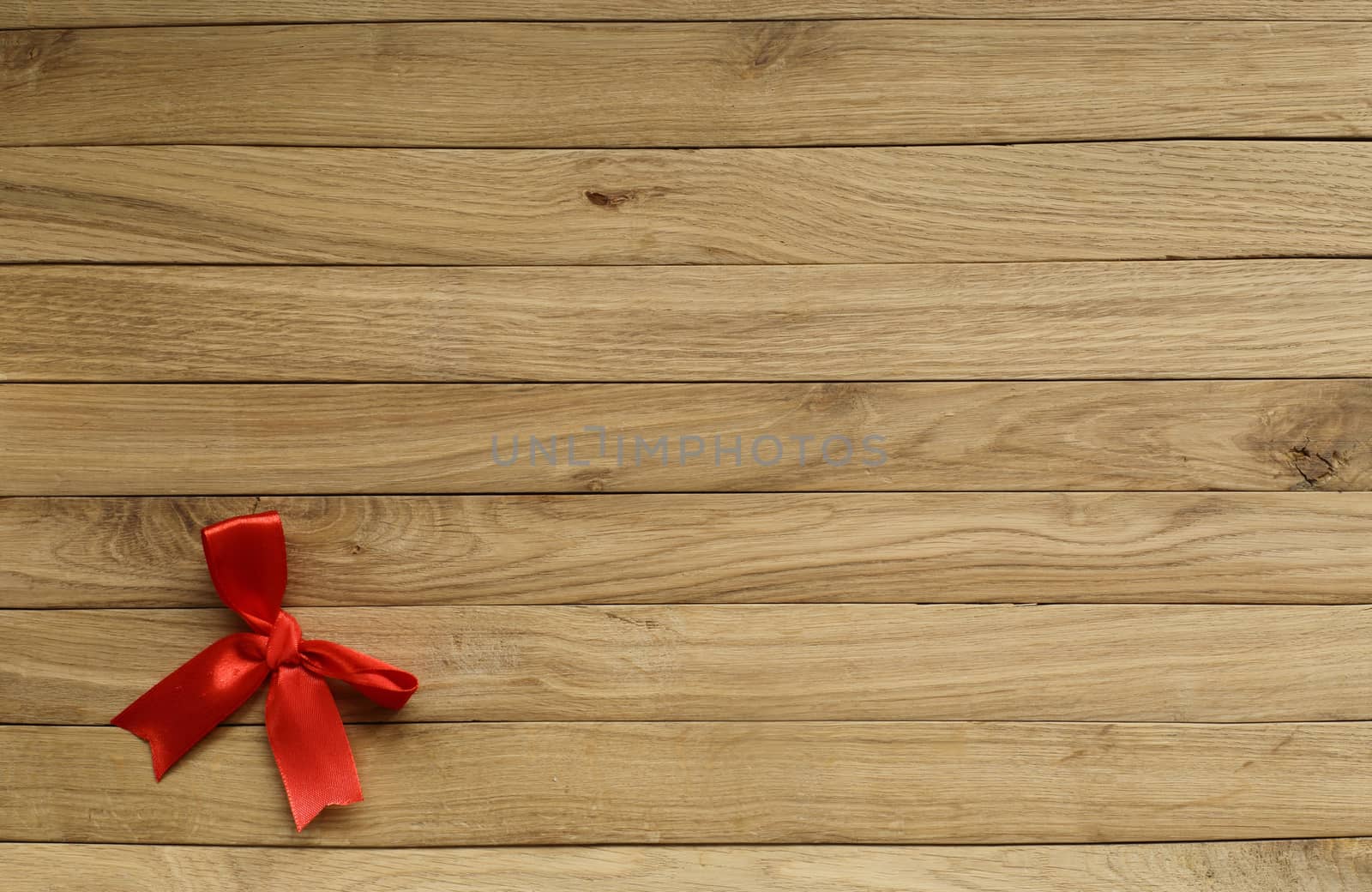old boards of oak. in the lower left corner is a red bow. suitable for background.