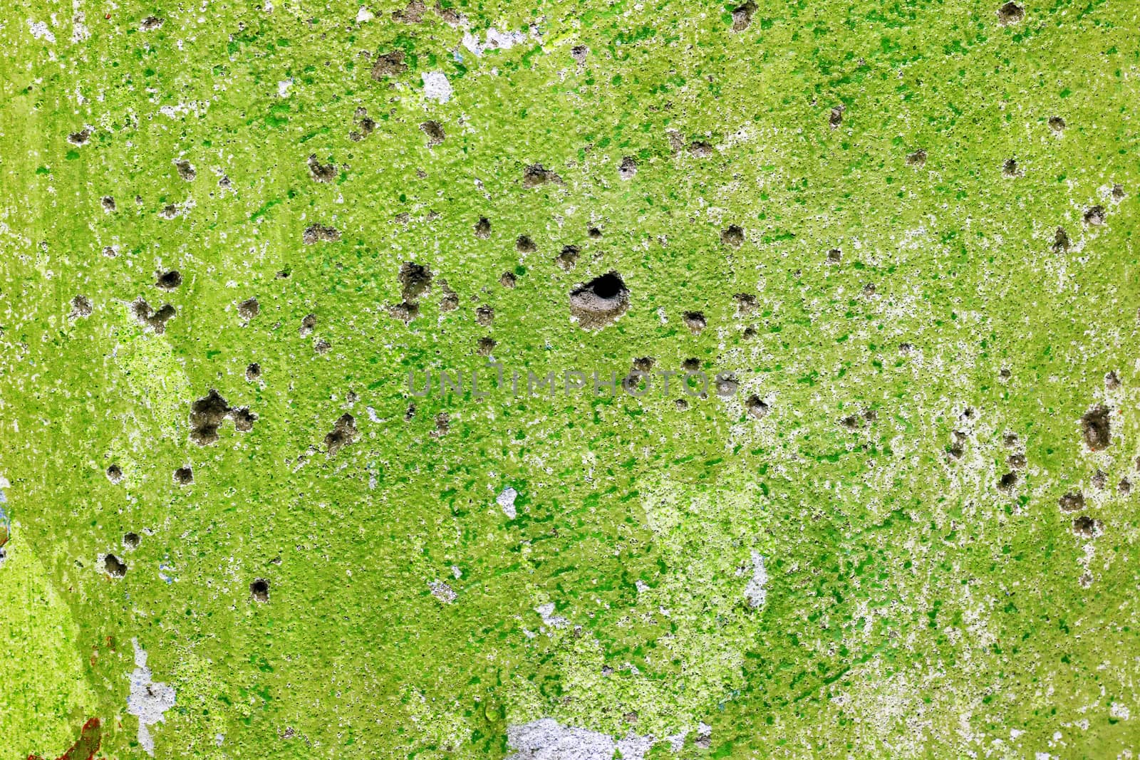 Green repair wall with bullets shoot holes background. Rough housework wallpaper design backdrop. Color room interior decoration texture template