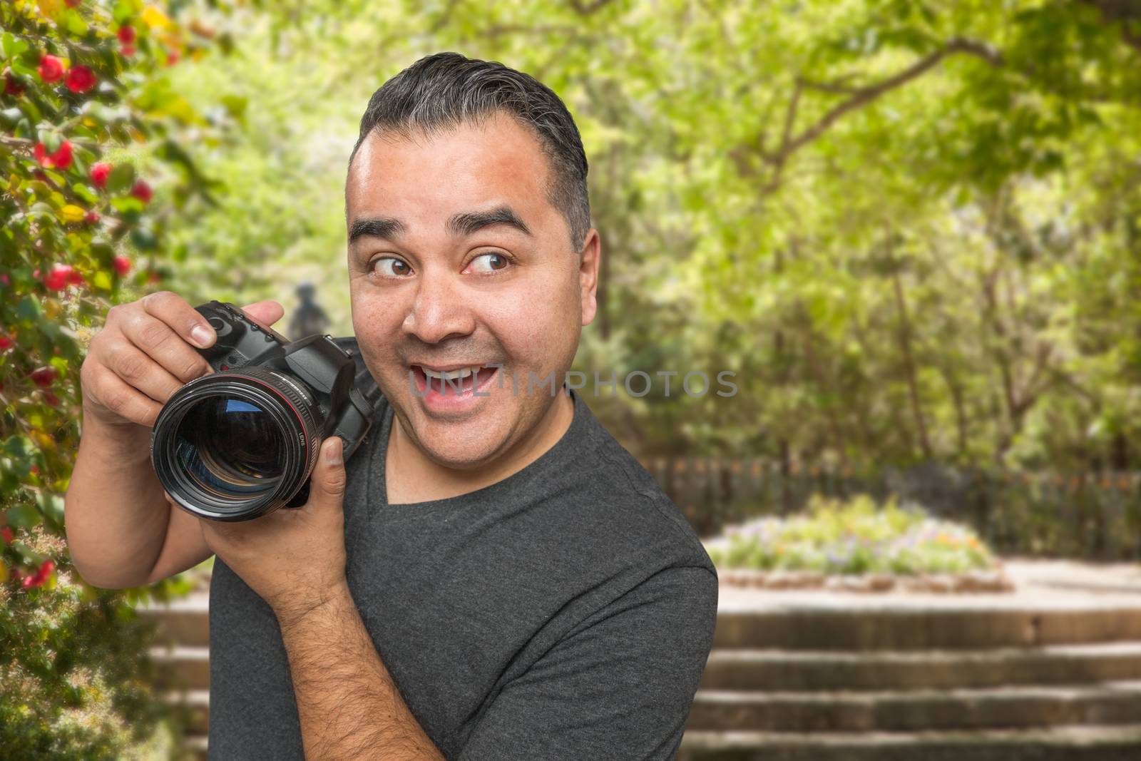 Hispanic Young Male Photographer With DSLR Camera Outdoors by Feverpitched