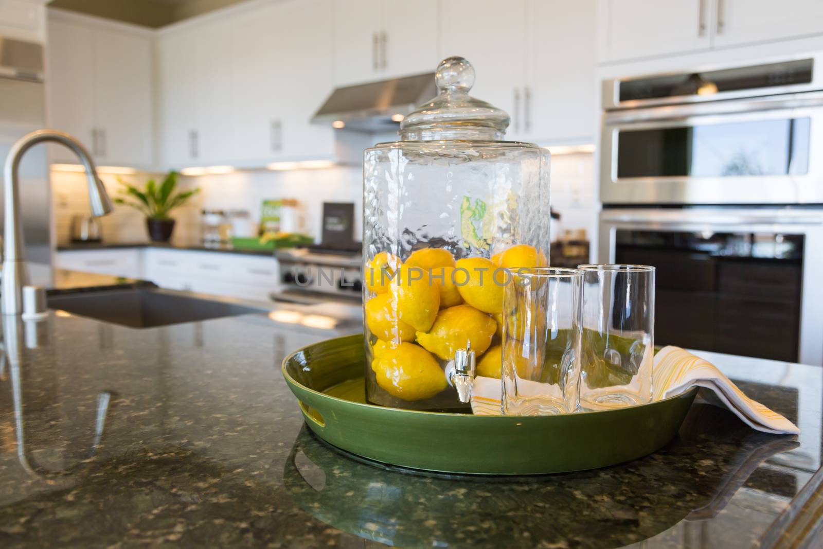 Abstract of Interior Kitchen Counter with Lemon Filled Pitcher and Drinking Glasses.