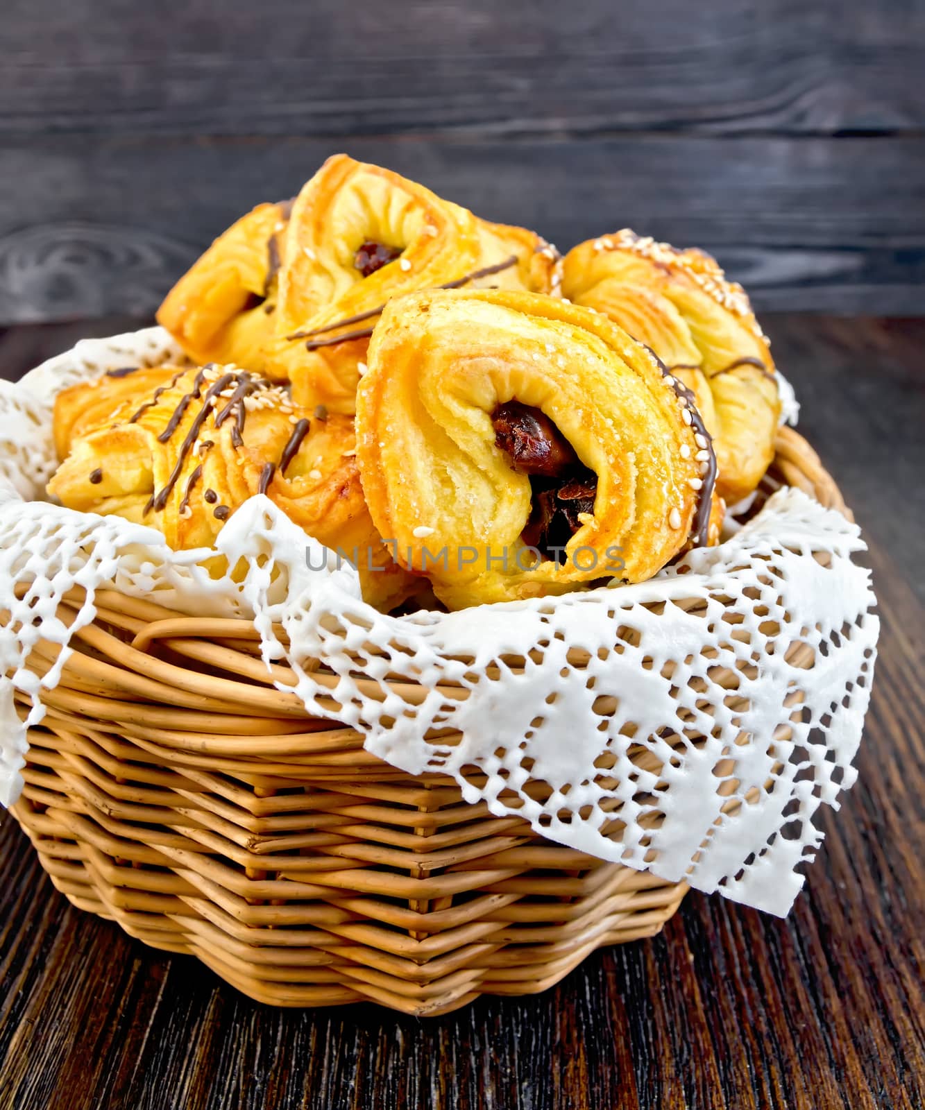 Cookies with dates in a wicker basket with a napkin on a dark wooden board