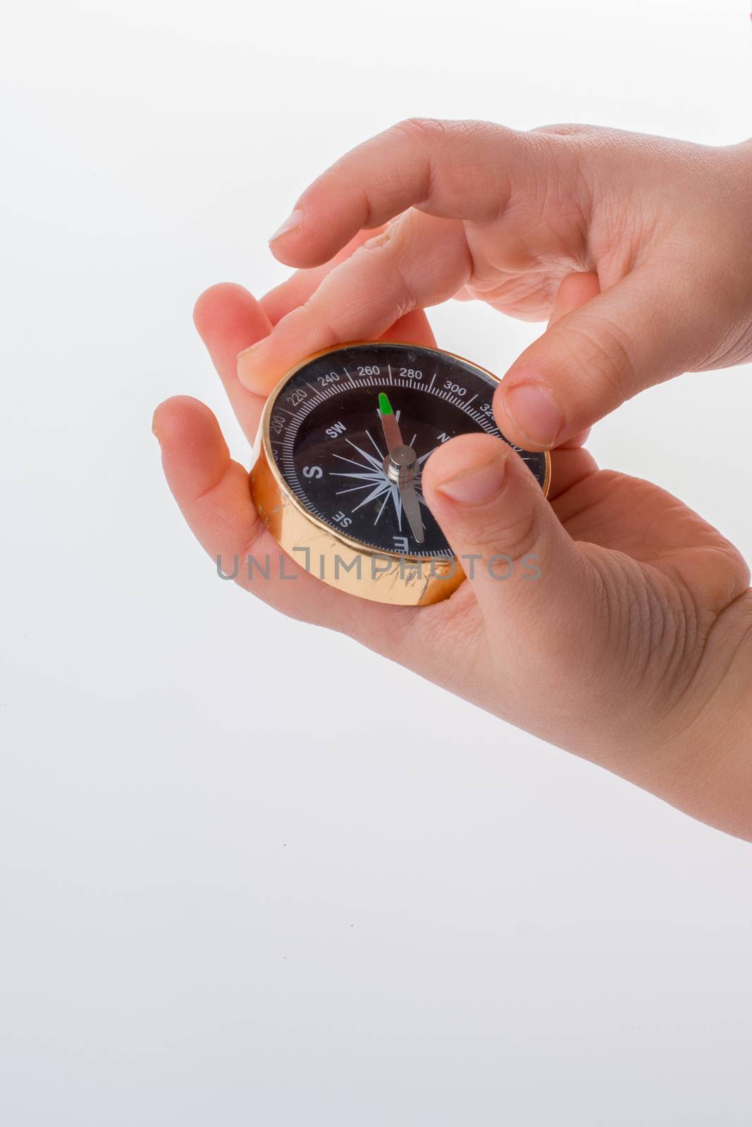 Child hand holding a compass  on a white background