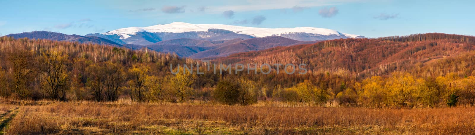springtime countryside with snowy mountain in the distance. lovely panorama of Runa mountain in evening