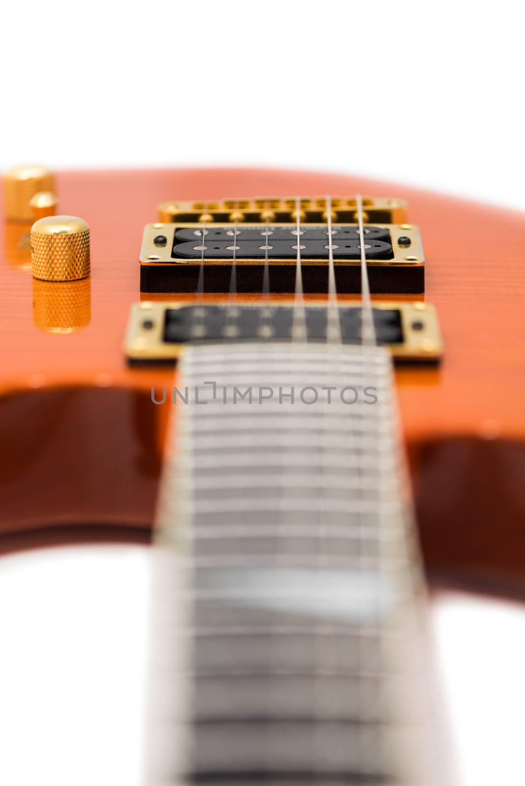 Detail of Orange Electric Guitar Body with Defocused Fretboard Isolated on White Background