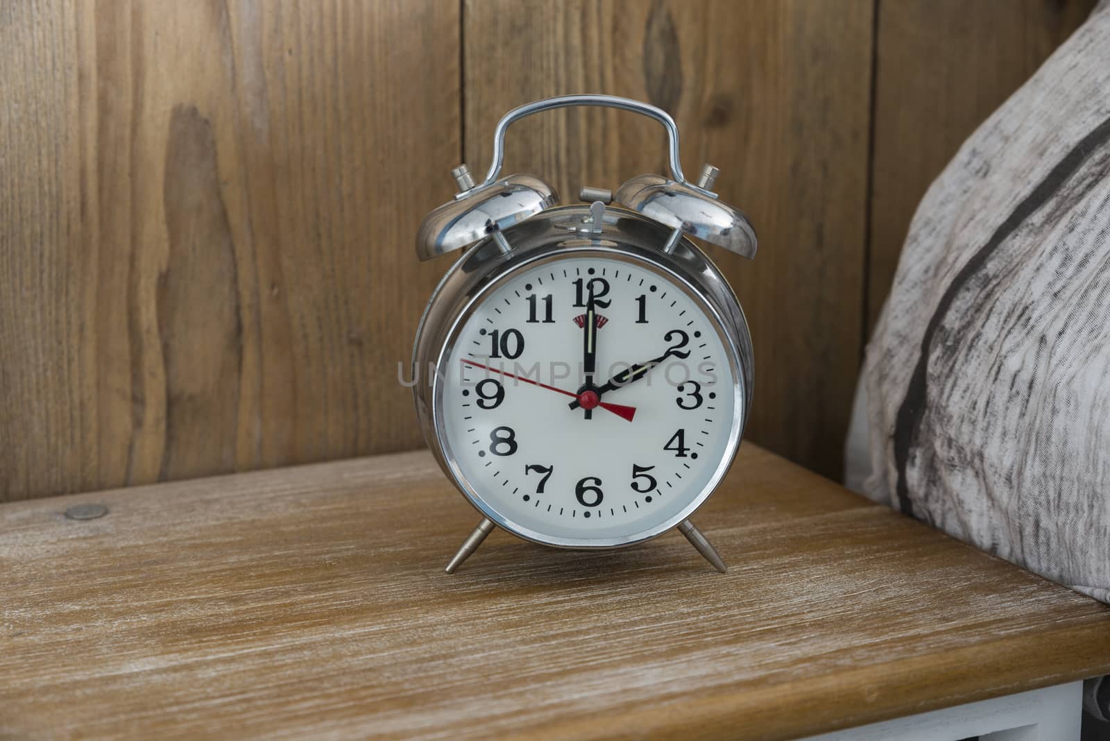 An old fashioned silver coloured bed side analogue pre digital alarm clock