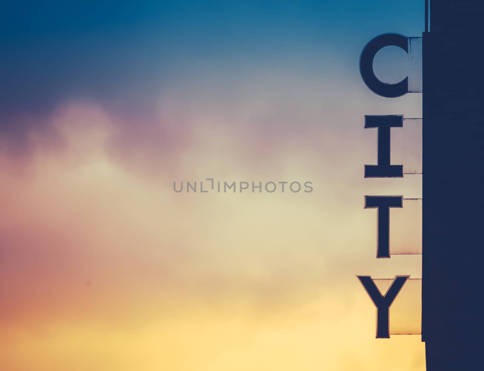 A Silhouette Of A City Sign On The Side Of A Building At Sunset With Copy Space