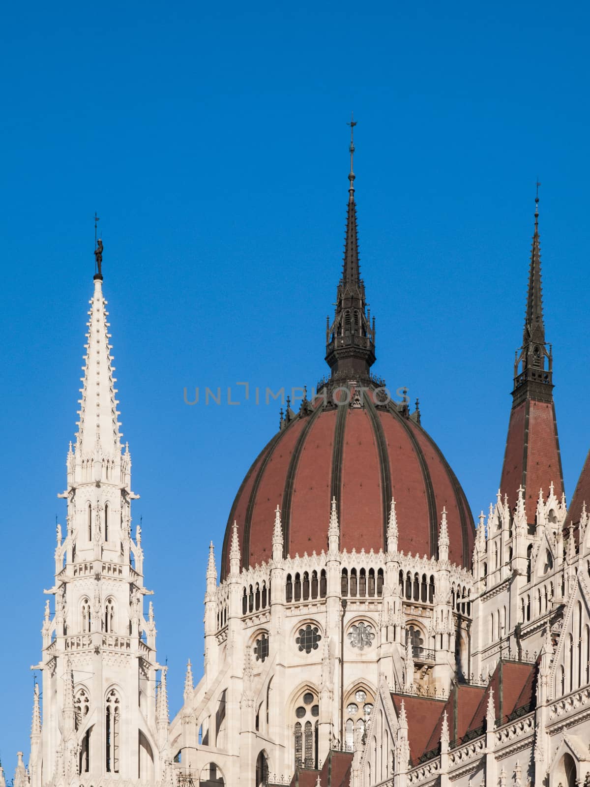 Detailed view of historical building of Hungarian Parliament, aka Orszaghaz, with typical central dome on clear blue sky background. Budapest, Hungary, Europe. It is notable landmark and seat of the National Assembly of Hungary. UNESCO World Heritage Site.