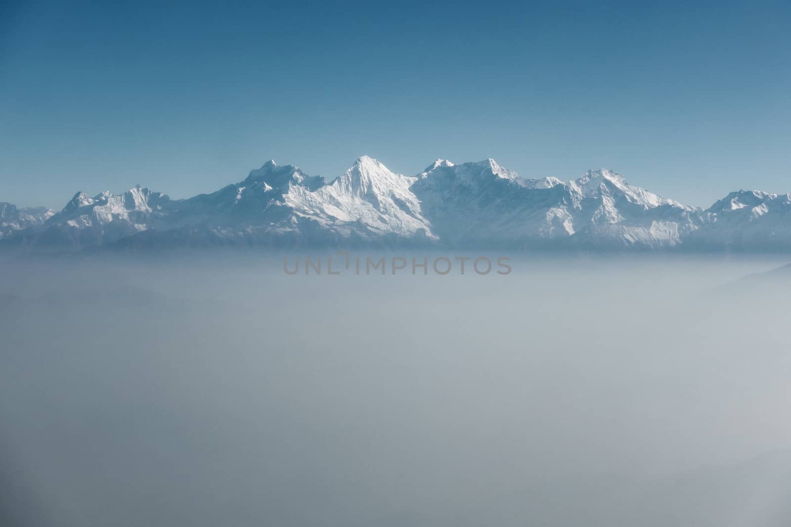 The Himalayas as seen from an airplane in Nepal. Layer of clouds beneath the mountain tops.