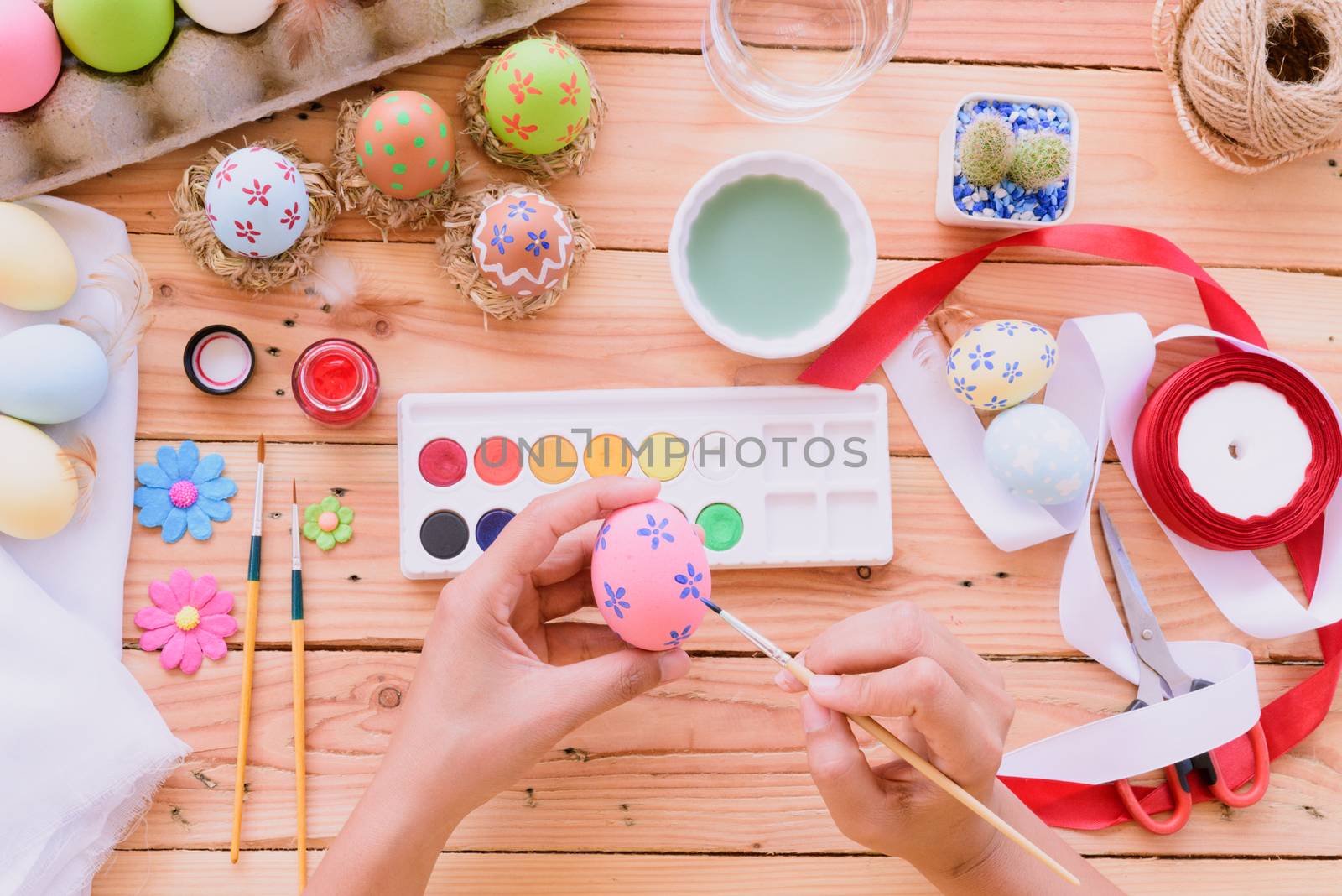 Happy easter! A woman hand painting Easter eggs. Happy family preparing for Easter.