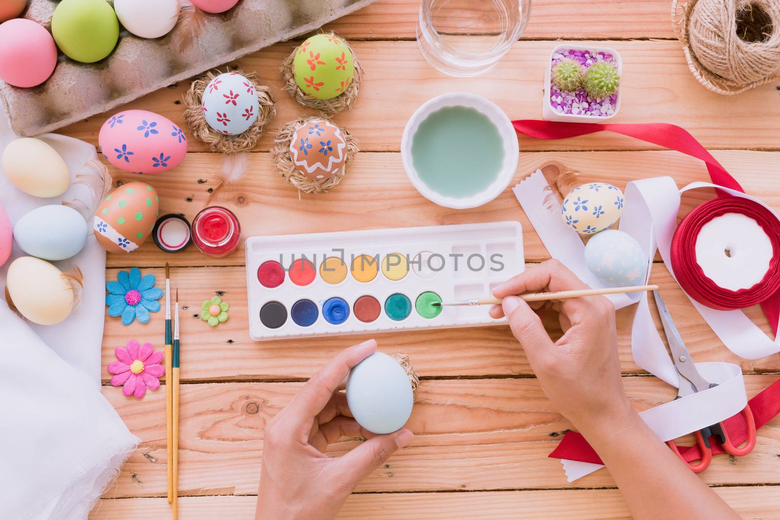 Happy easter! A woman hand painting Easter eggs. Happy family pr by spukkato