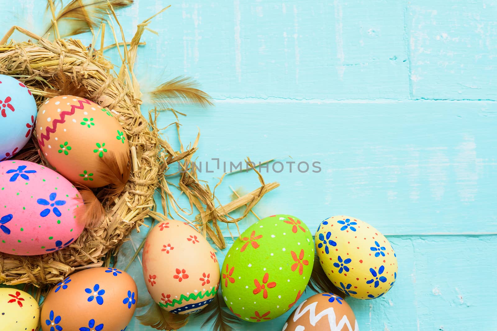 Happy easter! Colorful of Easter eggs in nest on pastel color br by spukkato