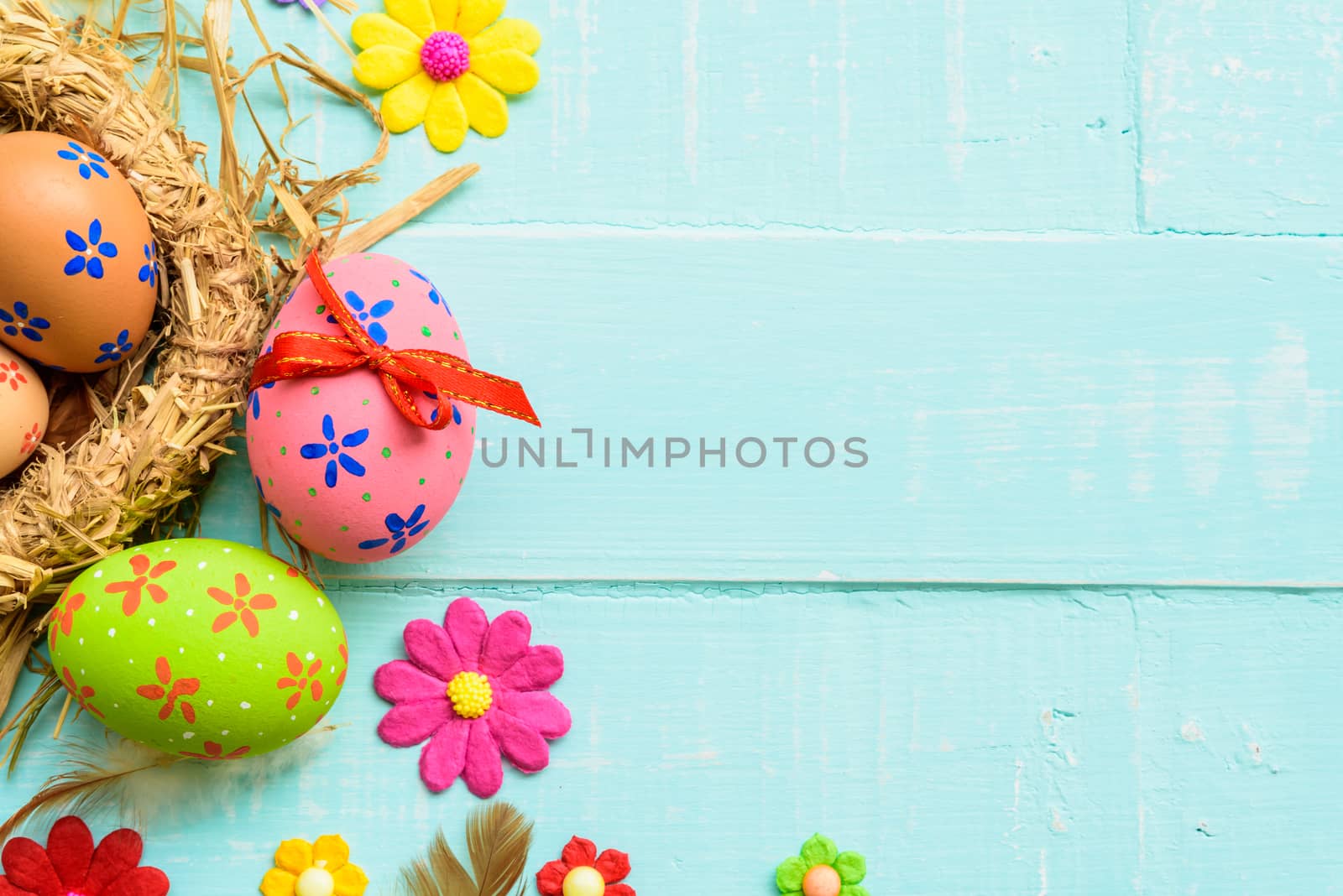 Happy easter! Colorful of Easter eggs in nest on pastel color bright green and white wooden background.