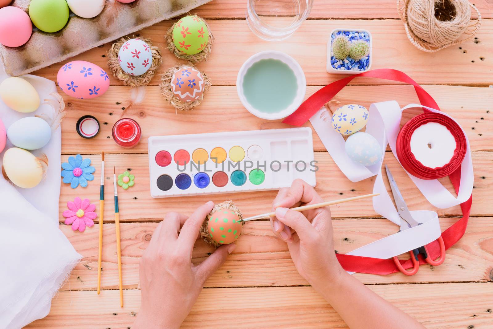 Happy easter! A woman hand painting Easter eggs. Happy family pr by spukkato