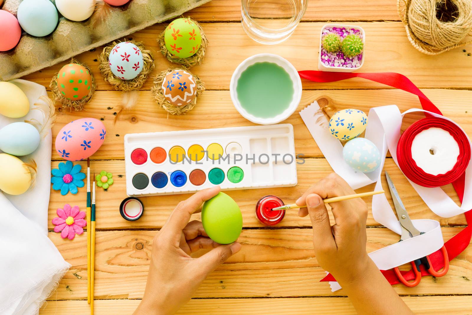 Happy easter! A woman hand painting Easter eggs. Happy family pr by spukkato
