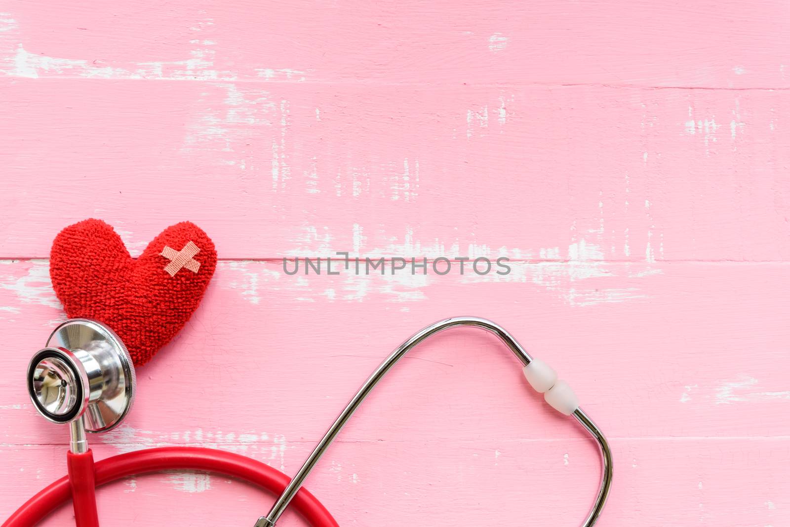 World health day, Healthcare and medical concept. Red heart with Stethoscope, notepad, thermometer and yellow Pill on Pastel white and pink wooden background.
