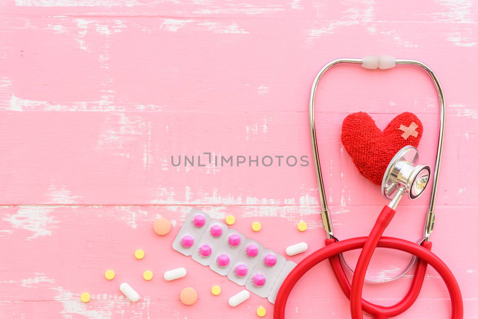 World health day, Healthcare and medical concept. Red heart with Stethoscope, notepad or notebook, thermometer and yellow Pill on Pastel white and blue wooden table background texture.