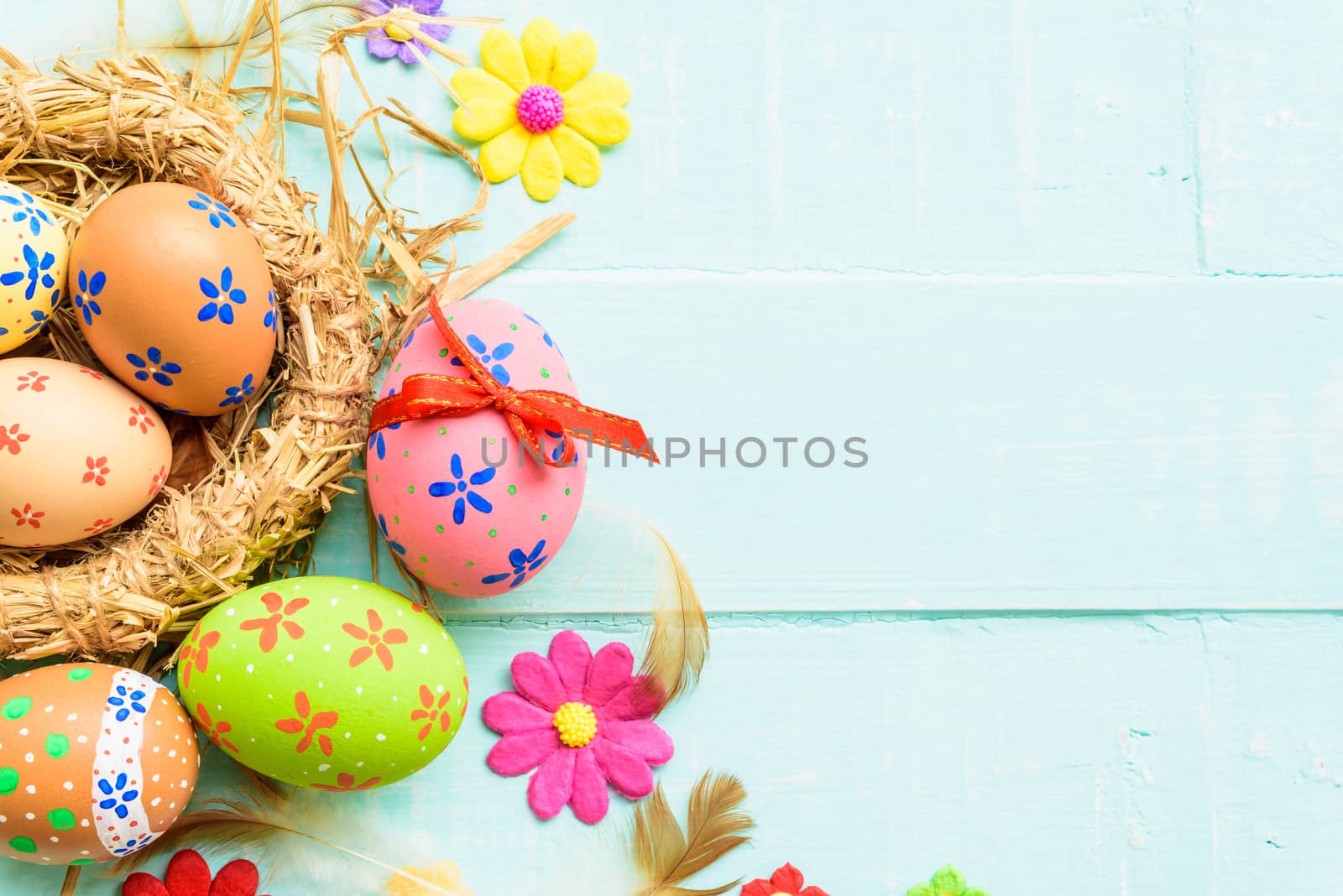 Happy easter! Colorful of Easter eggs in nest on pastel color bright green and white wooden background.