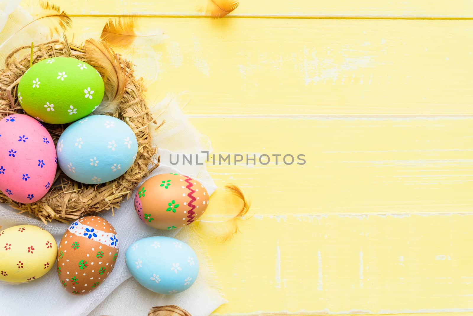 Happy easter! Colorful of Easter eggs in nest on pastel color bright green and white wooden background.