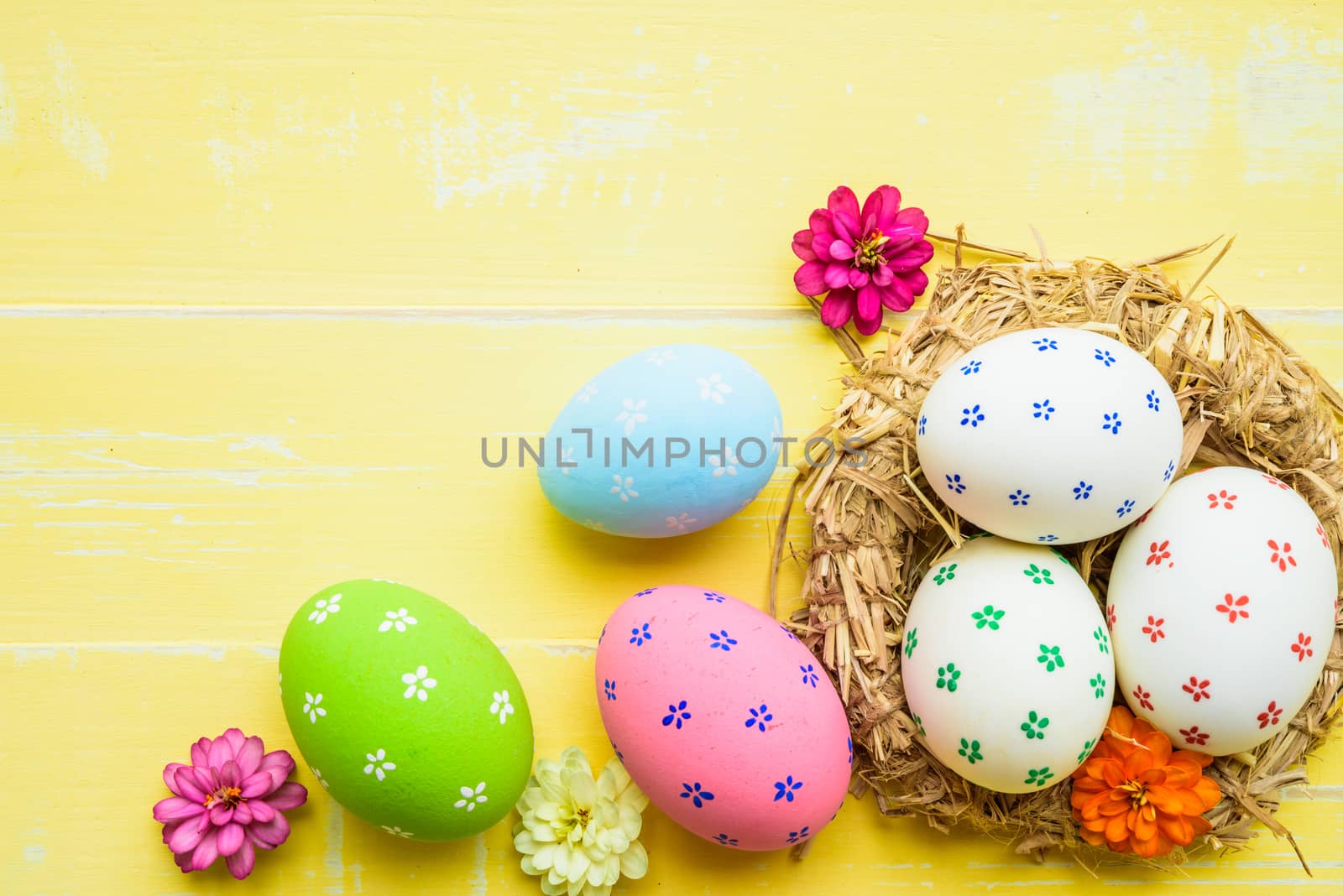 Happy easter! Colorful of Easter eggs in nest on pastel color br by spukkato