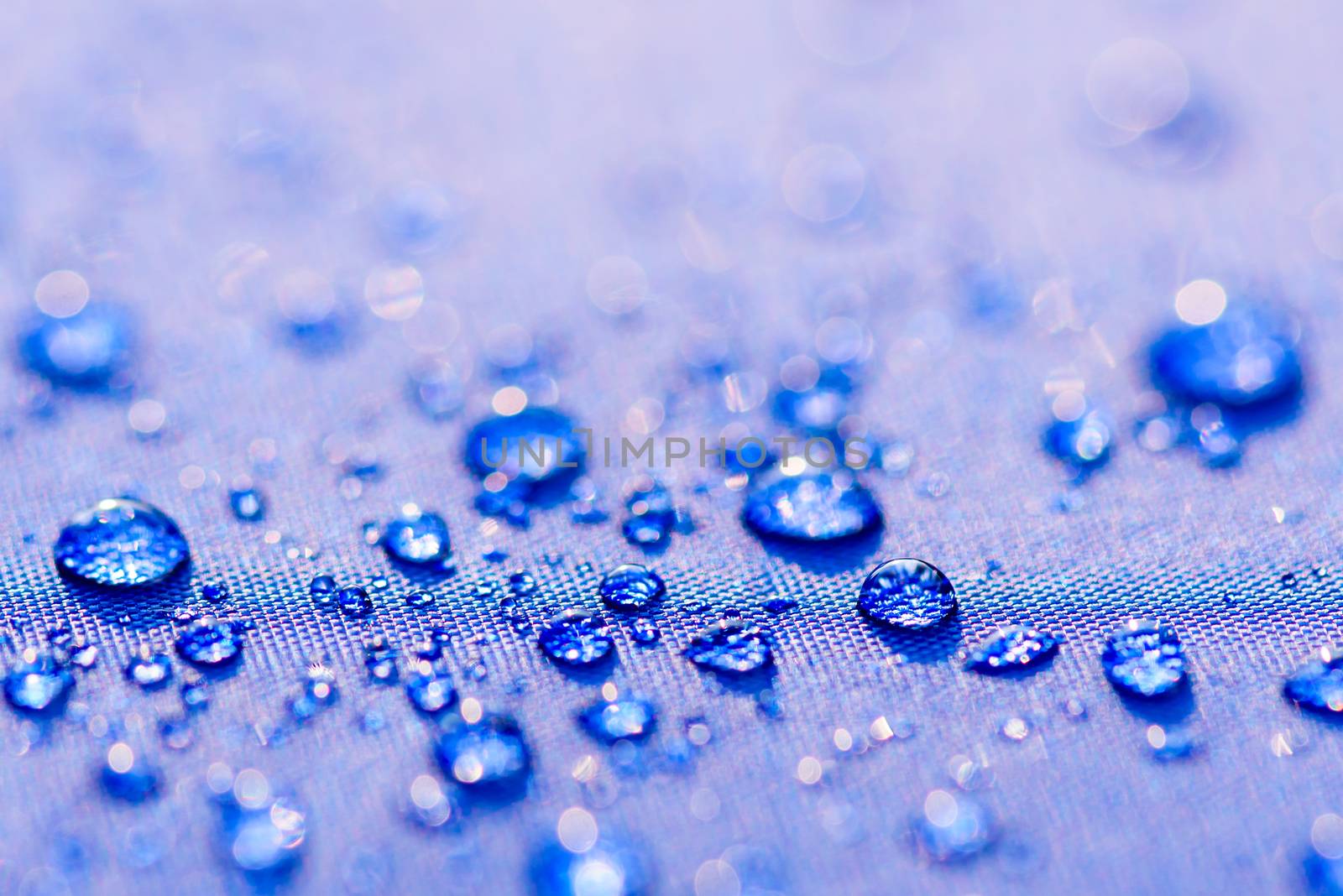 Close up Water drops pattern over a blue waterproof cloth backgr by spukkato