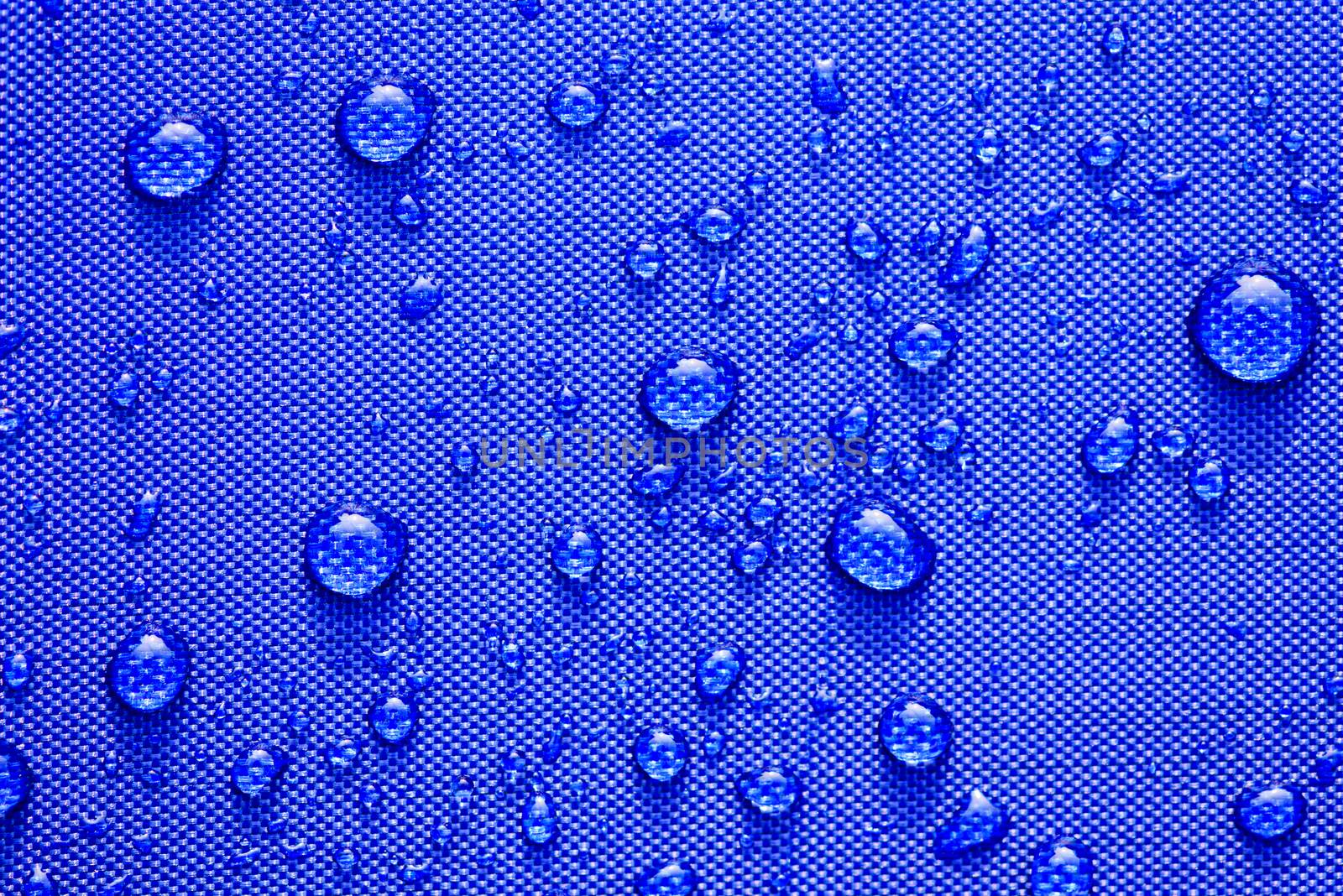 Close up Water drops pattern over a blue waterproof cloth backgr by spukkato