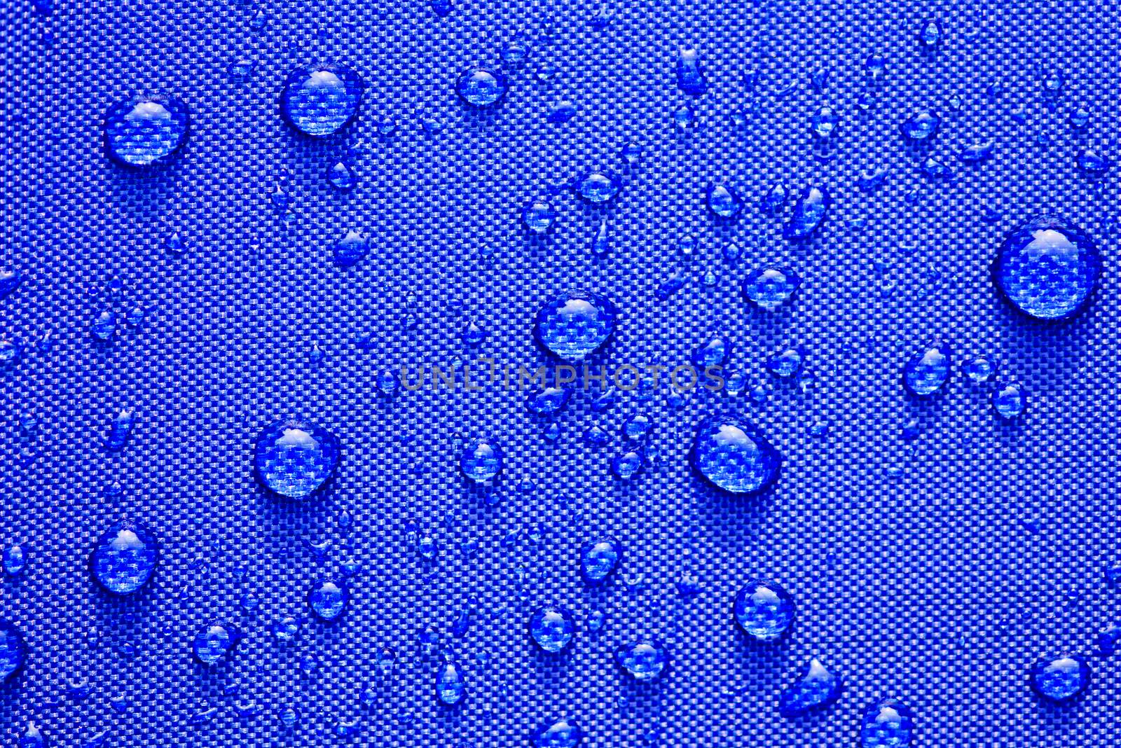 Close up Water drops pattern over a blue waterproof cloth background. World Water Day concept.