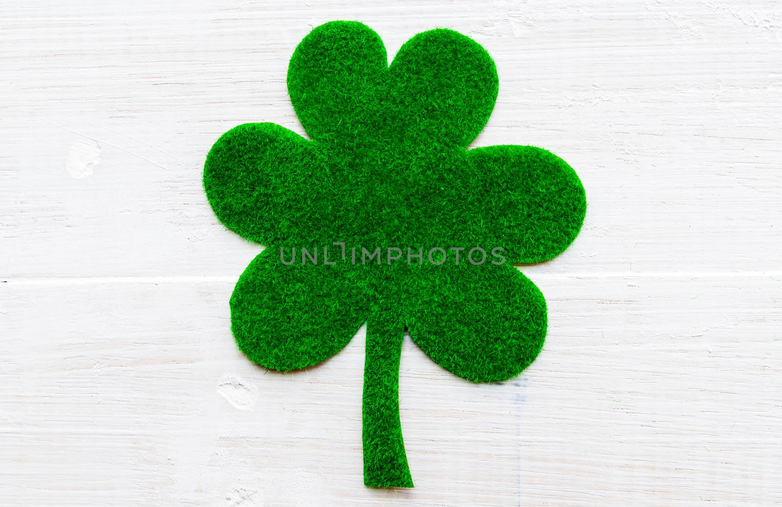Happy St Patricks Day message on green paper clover and white wo by spukkato