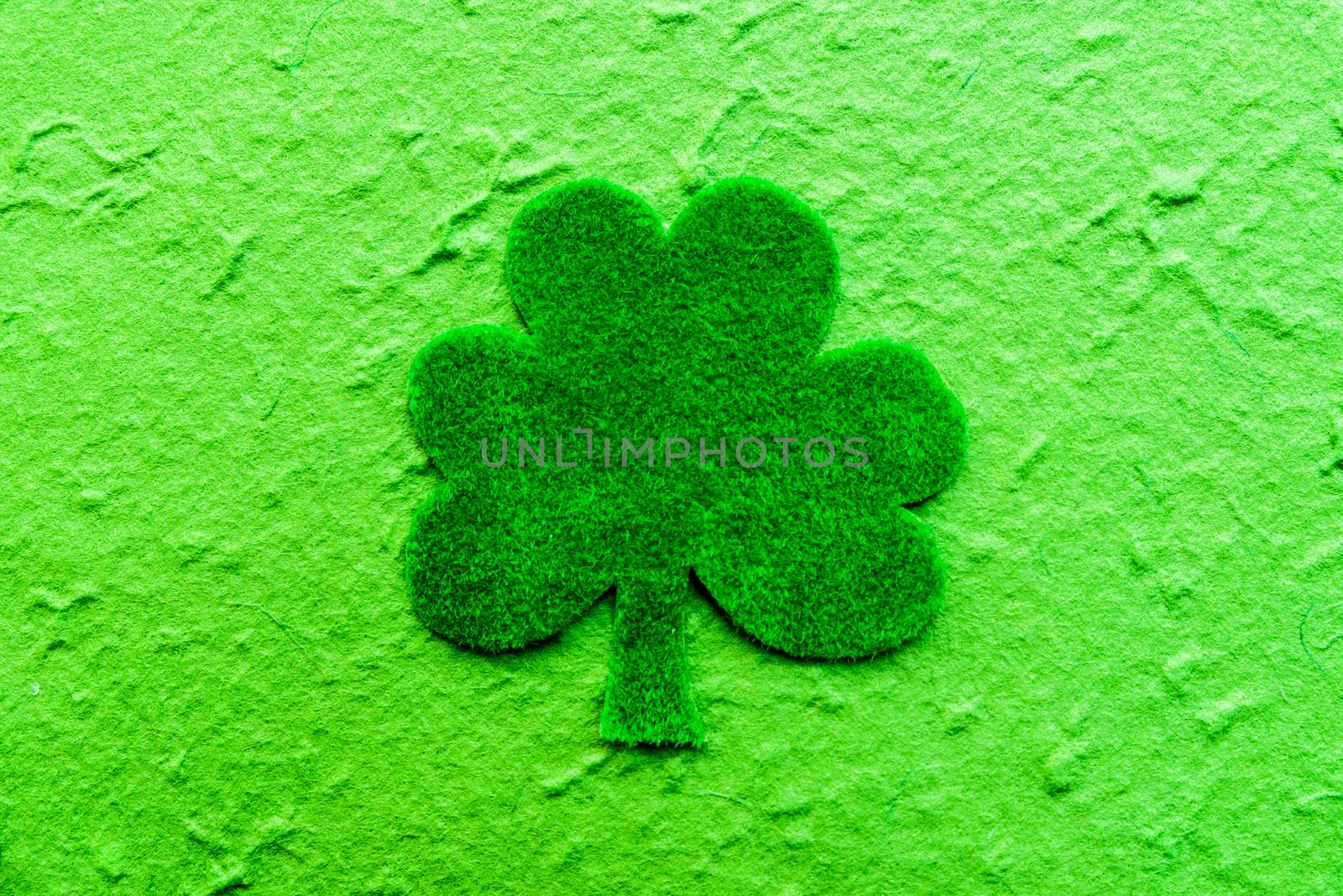 Happy St Patricks Day message on green paper clover and bright green Mulberry paper background