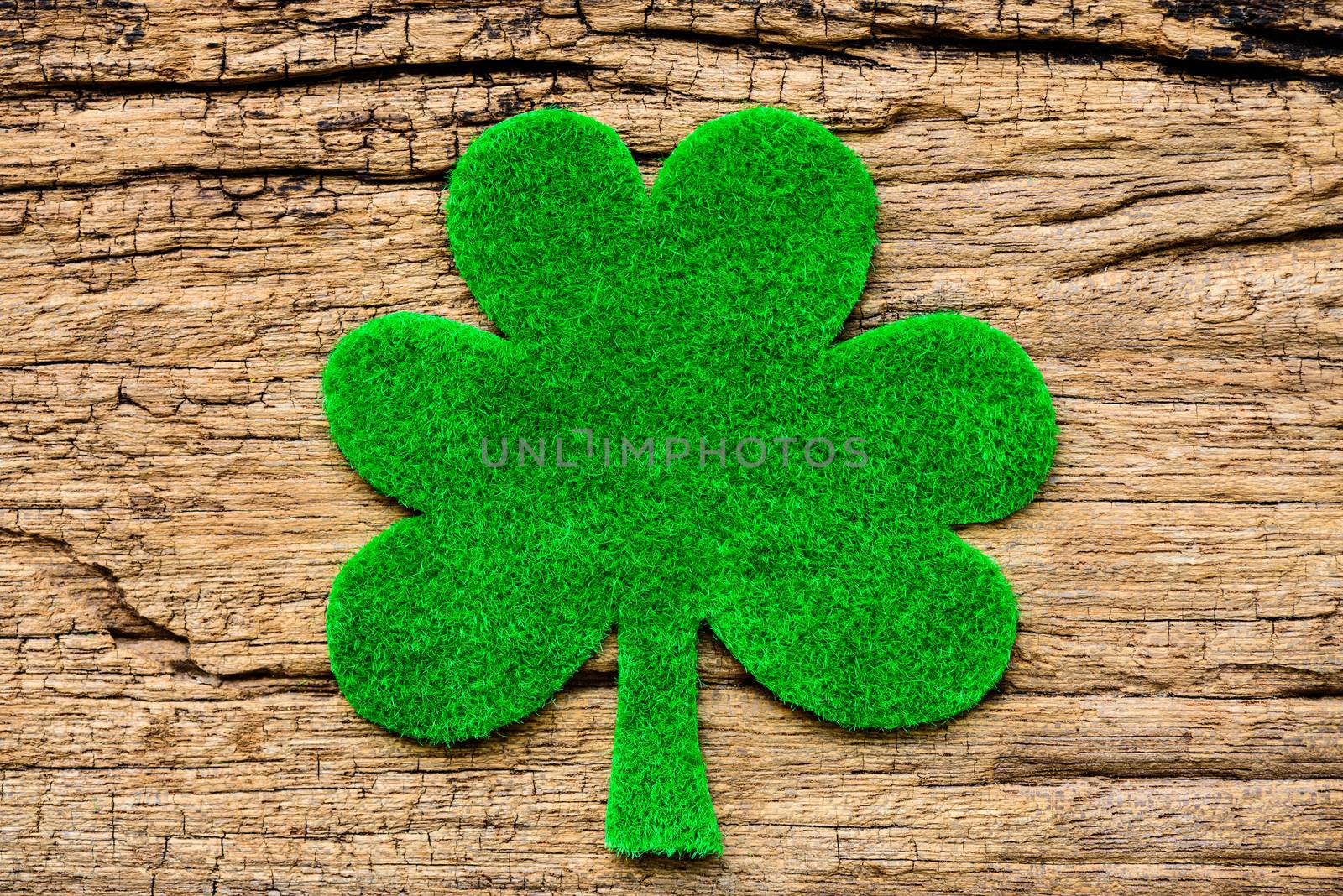 Happy St Patricks Day message with green clover leaf on wooden b by spukkato