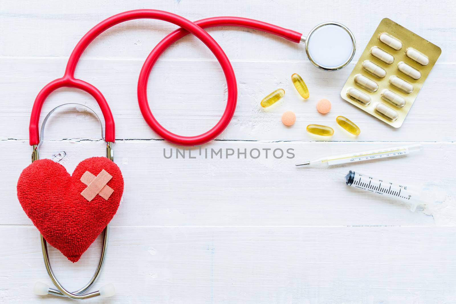 World health day, Healthcare and medical concept. Stethoscope, red heart, notepad or notebook, thermometer and yellow Pill on Pastel white and blue wooden table background texture.