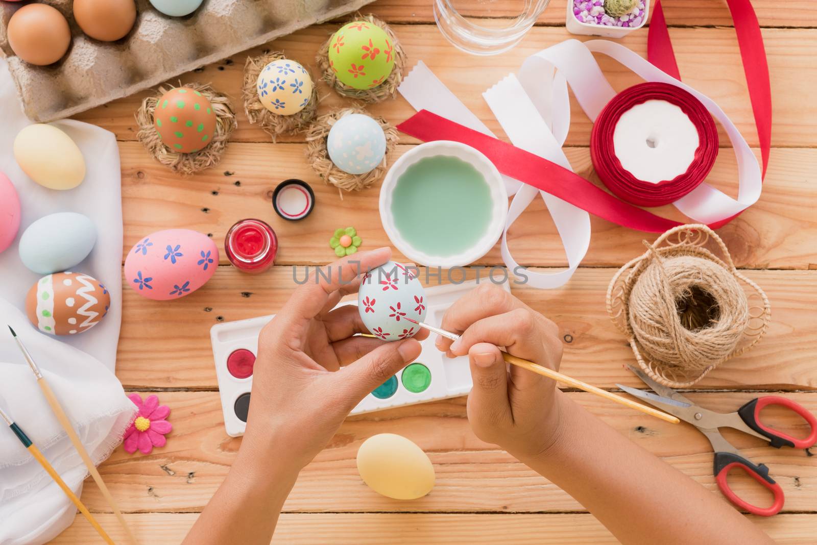 Happy easter! A woman hand painting Easter eggs. Happy family pr by spukkato