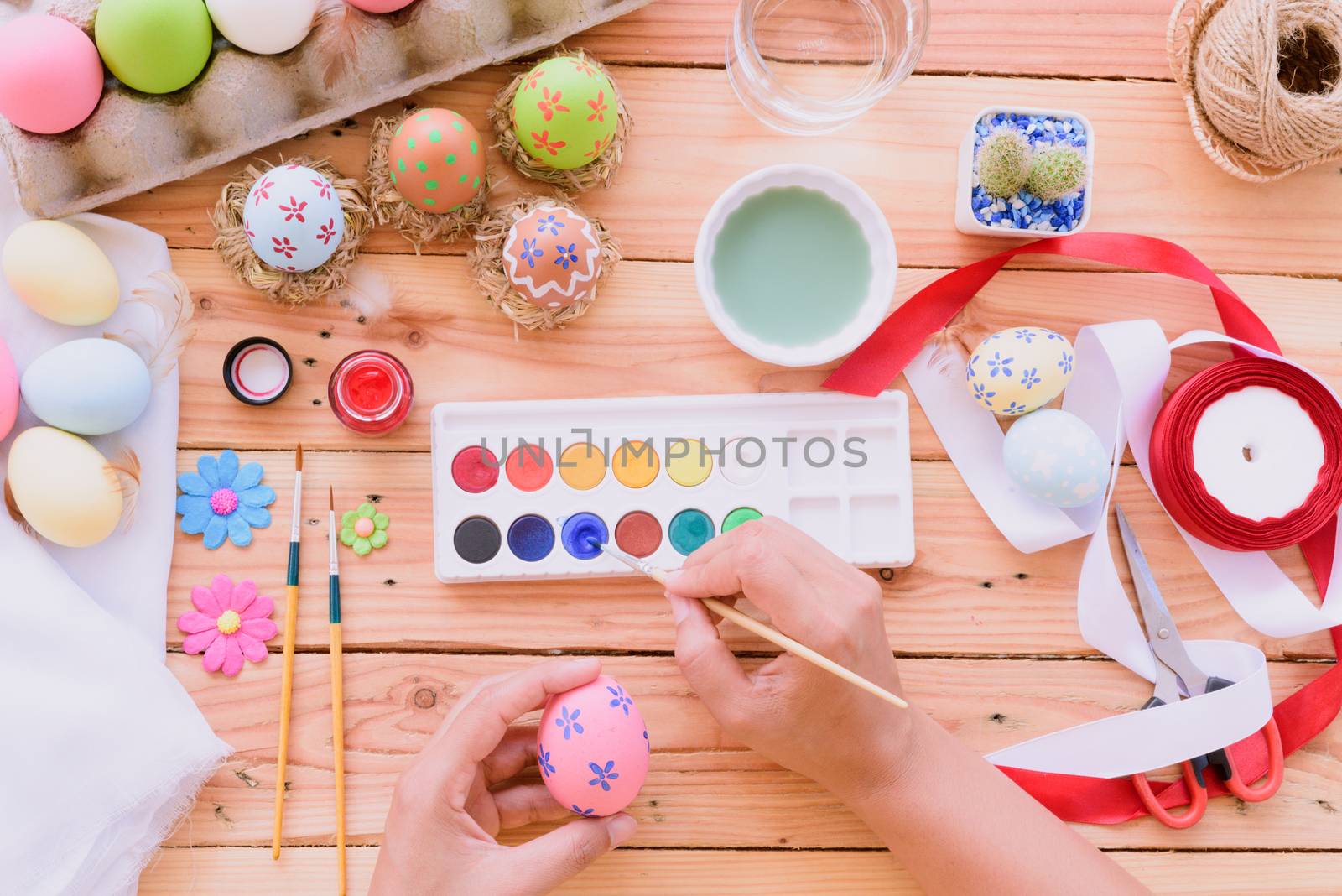 Happy easter! A woman hand painting Easter eggs. Happy family pr by spukkato