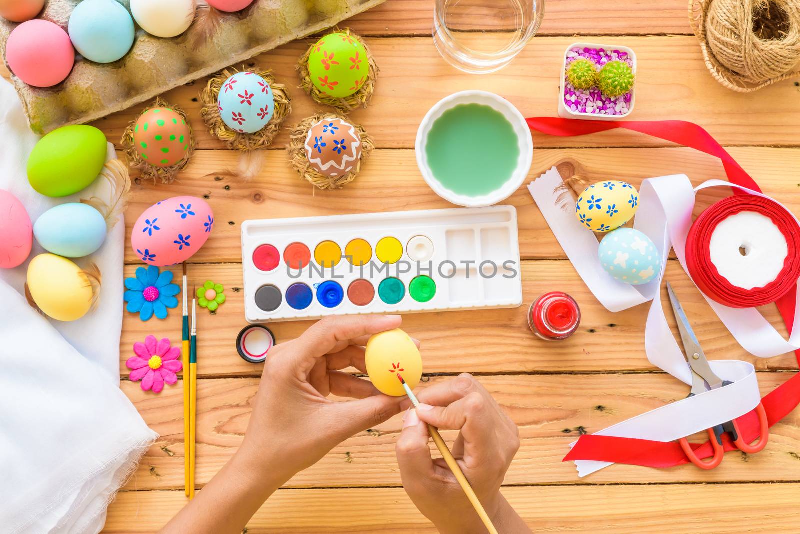 Happy easter! A woman hand painting Easter eggs. Happy family preparing for Easter.