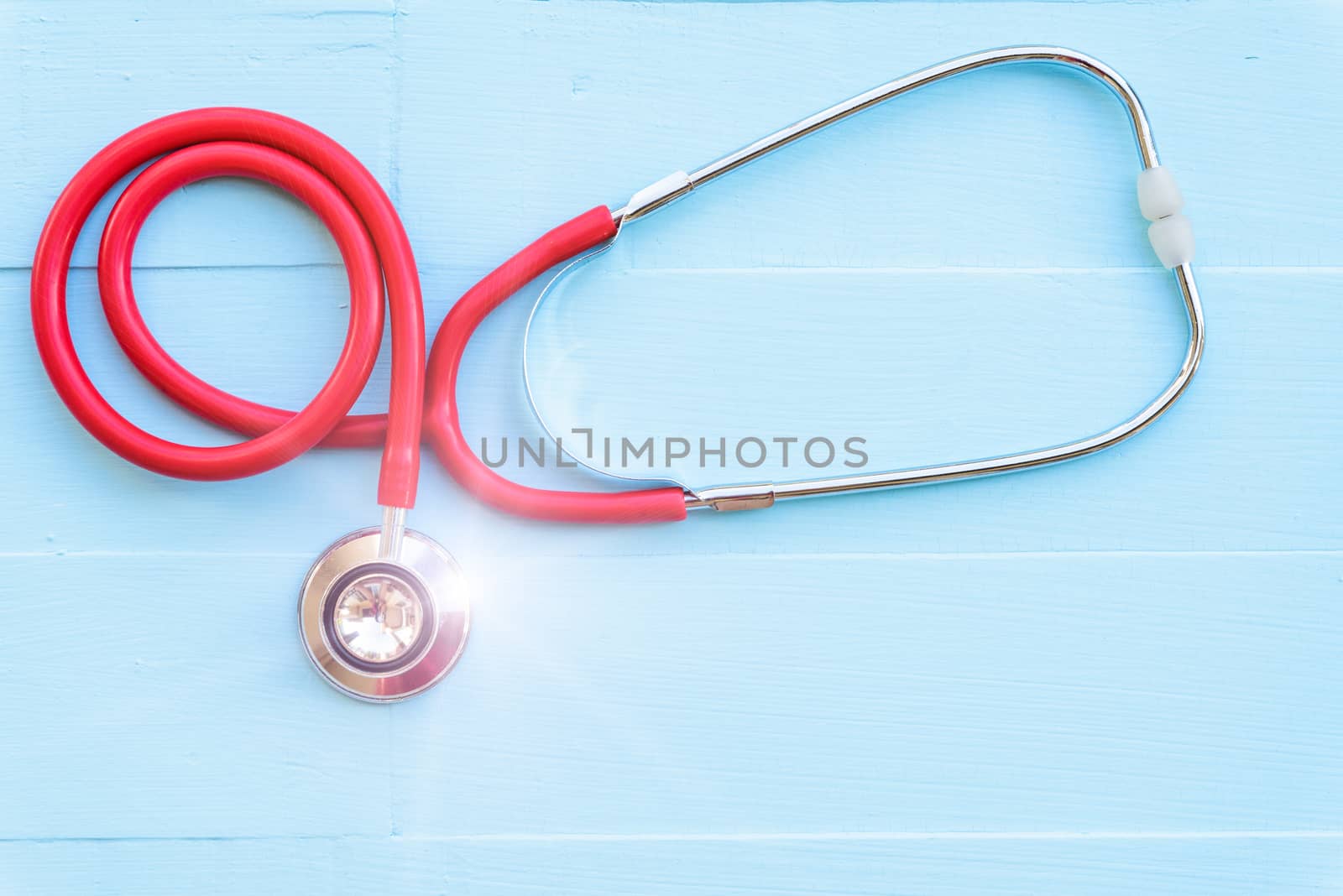 World health day, Healthcare and medical concept. Woman hand holding red heart with Stethoscope, notepad or notebook, thermometer and yellow Pill on Pastel white and blue wooden table background texture.