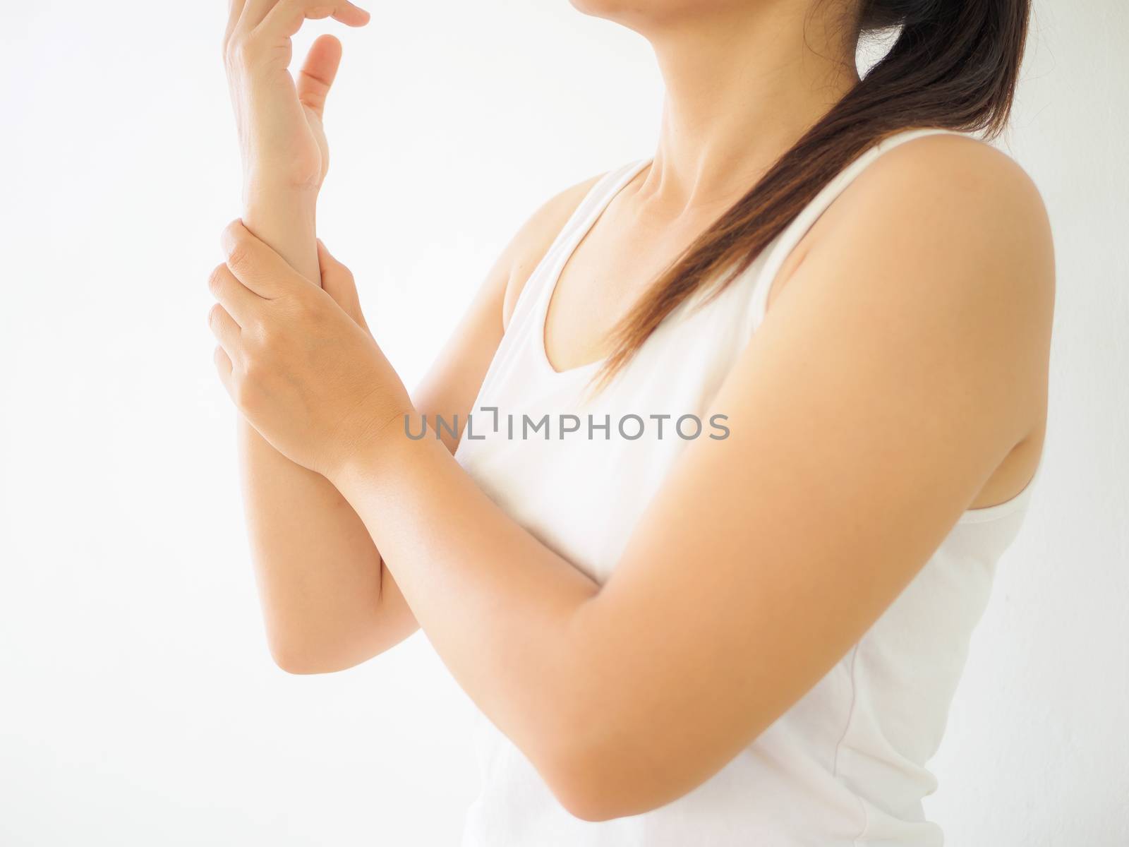 Close up young woman holding her wrist symptomatic Office Syndrome. Healthcare and arm pain concept.