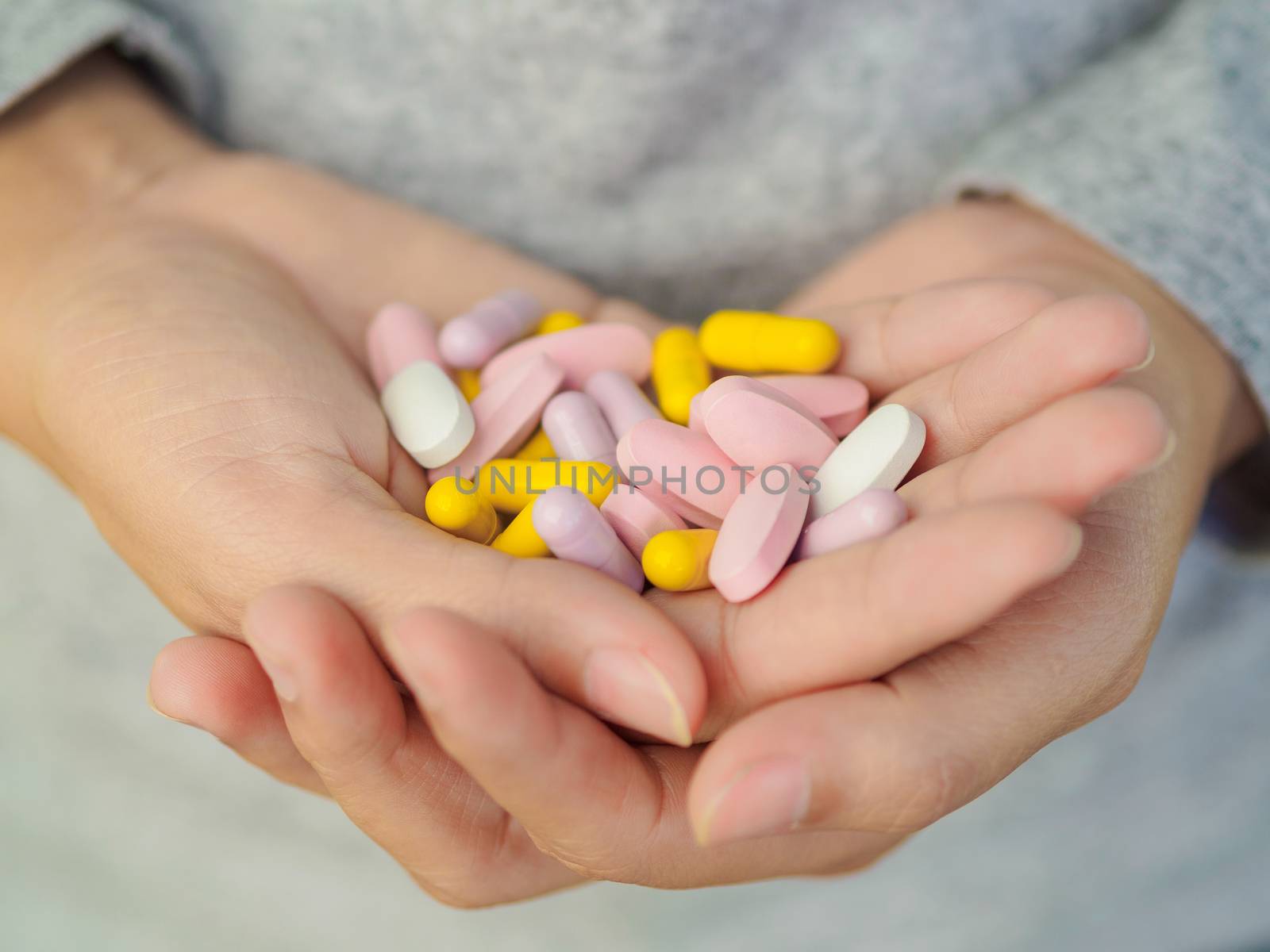 Close-up woman hand holding a lot of different pills. Health care and medical concept.