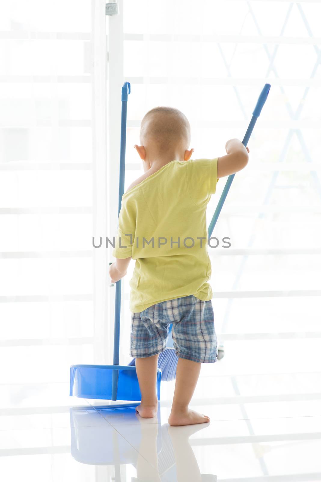 Asian toddler sweeping floor by szefei