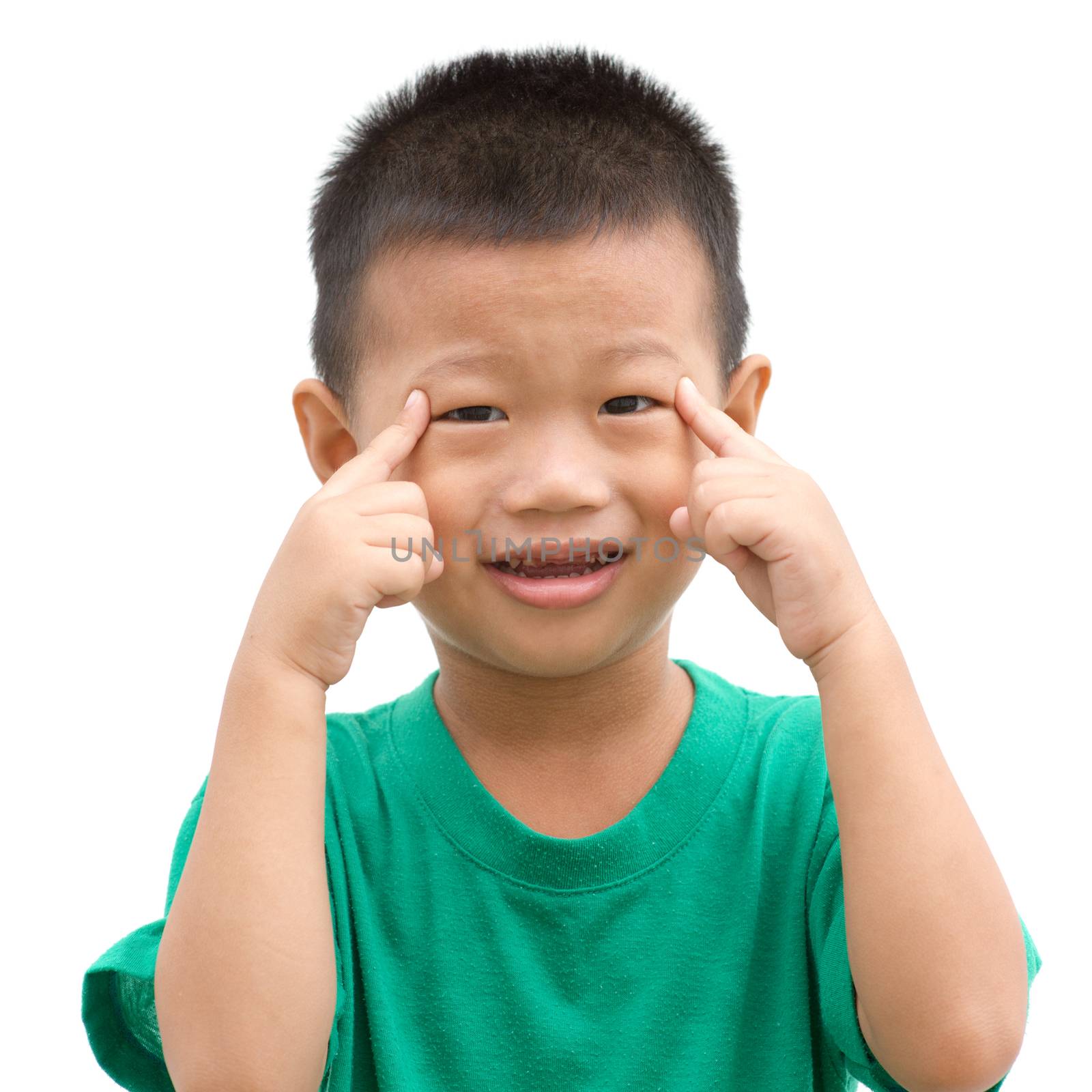 Happy Asian child pointing his eyes and smiling. Portrait of young boy showing body parts isolated on white background.