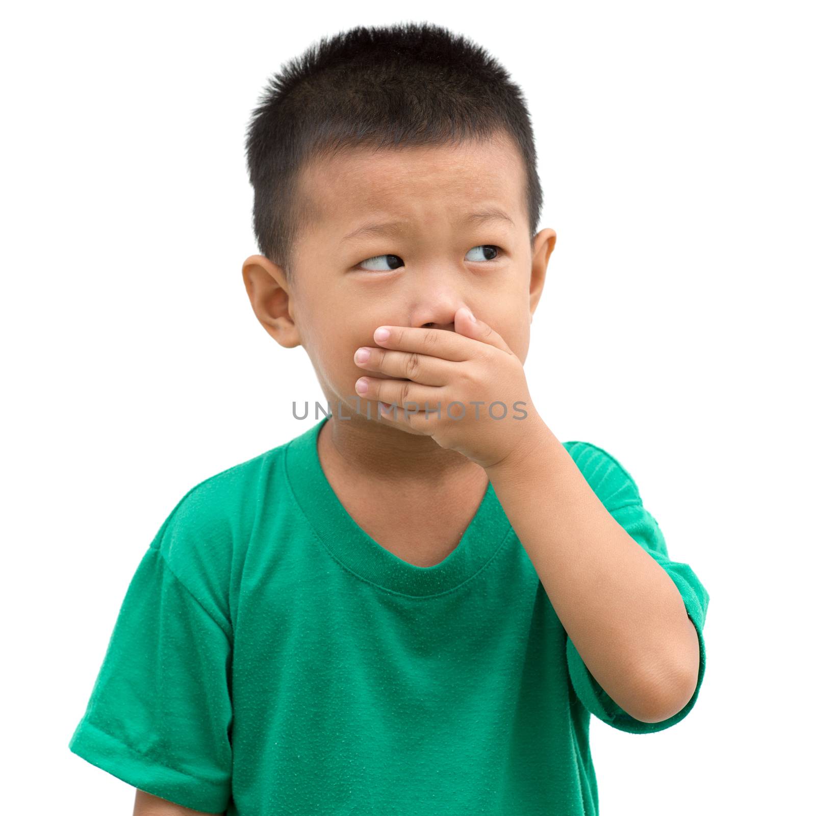 Asian child covering his mouth with hand and looking to side. Portrait of young boy isolated on white background.
