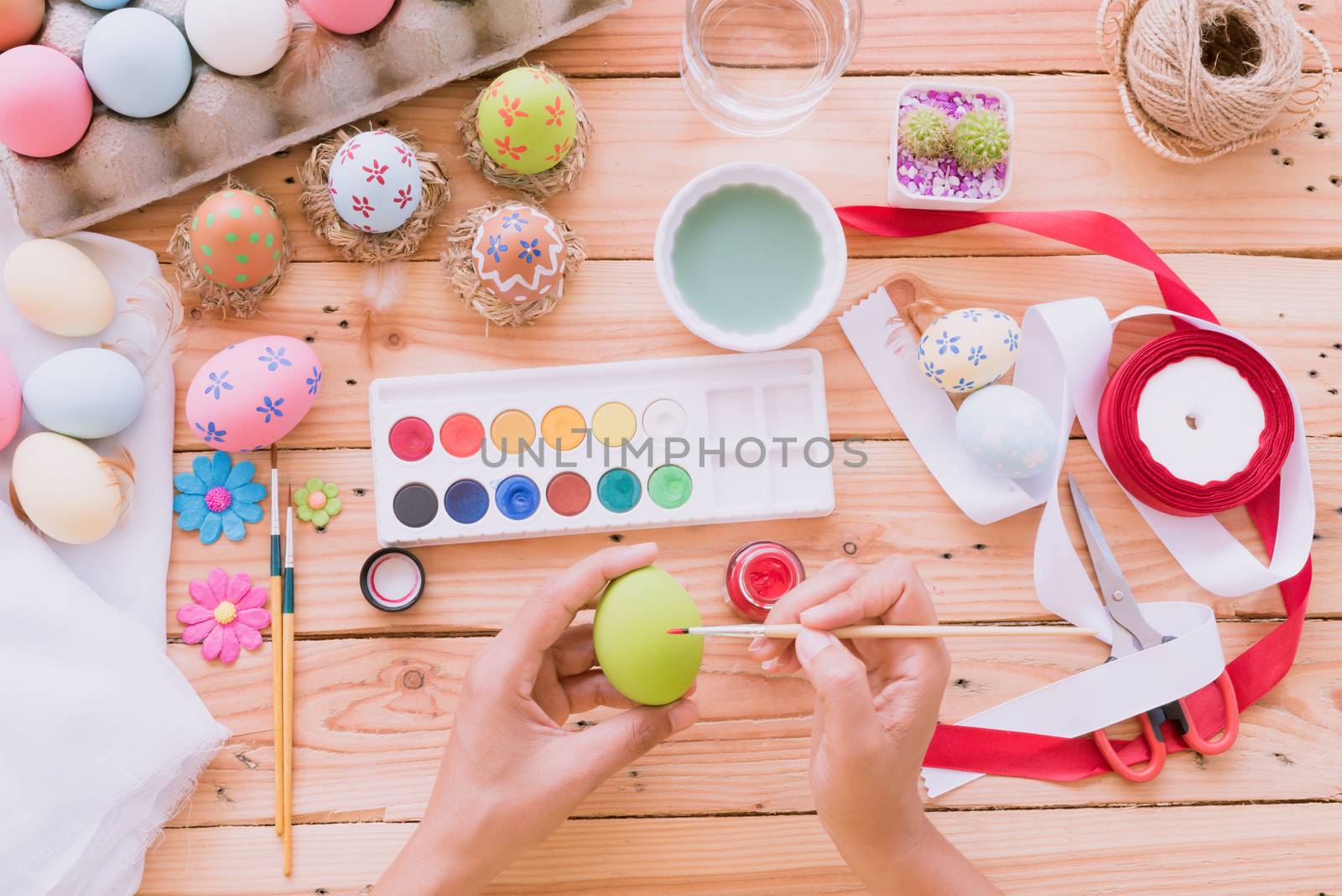 Happy easter! A woman hand painting Easter eggs. Happy family pr by spukkato