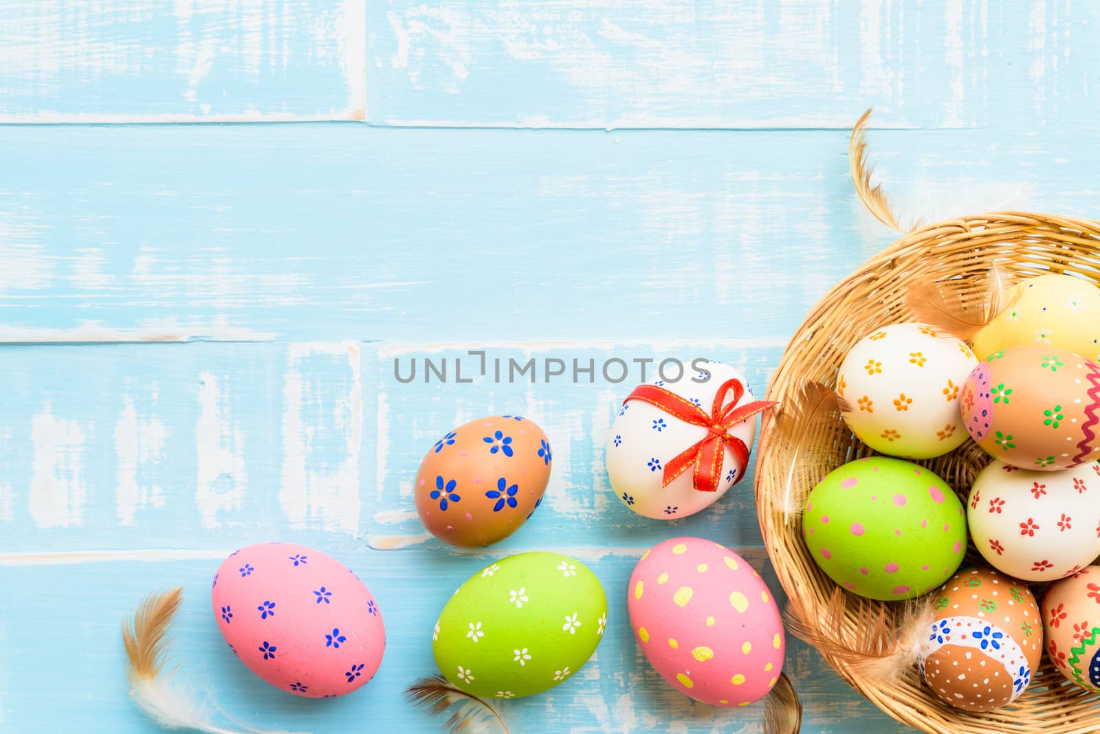 Happy easter! Colorful of Easter eggs in nest on pastel color br by spukkato