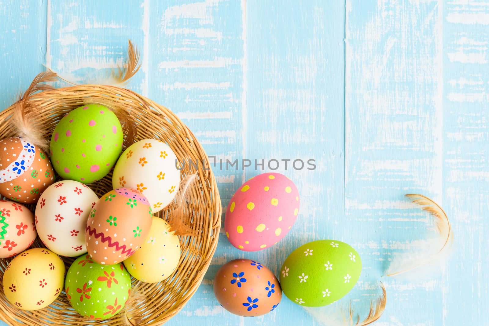 Happy easter! Colorful of Easter eggs in nest on pastel color bright green and white wooden background.