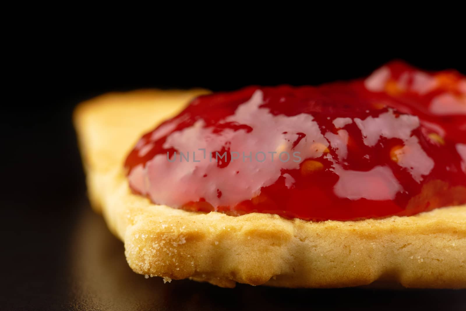 close-up of a cookie covered with raspberry jam