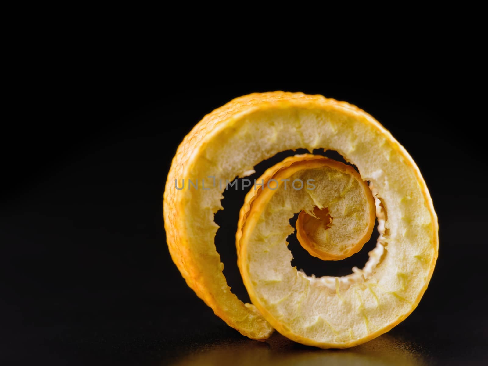 twist of citrus peel on a black background