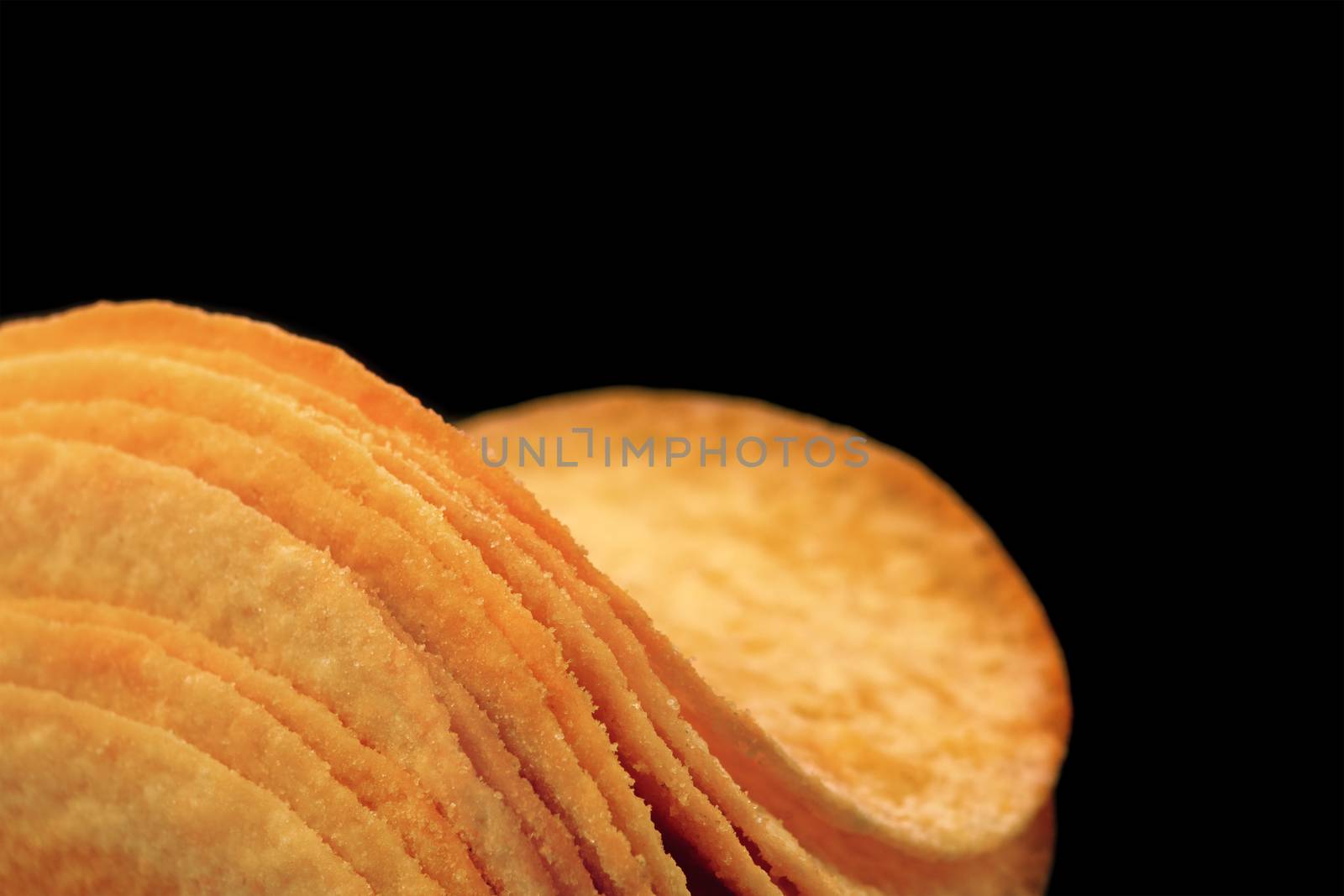 Close-up of curvy potato chips on a black background