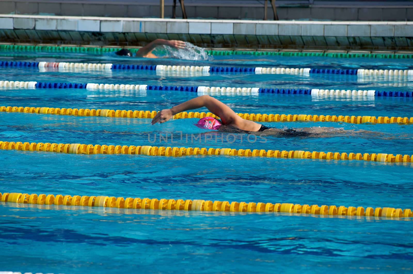 Girl swimmer in the outdoor swimming pool