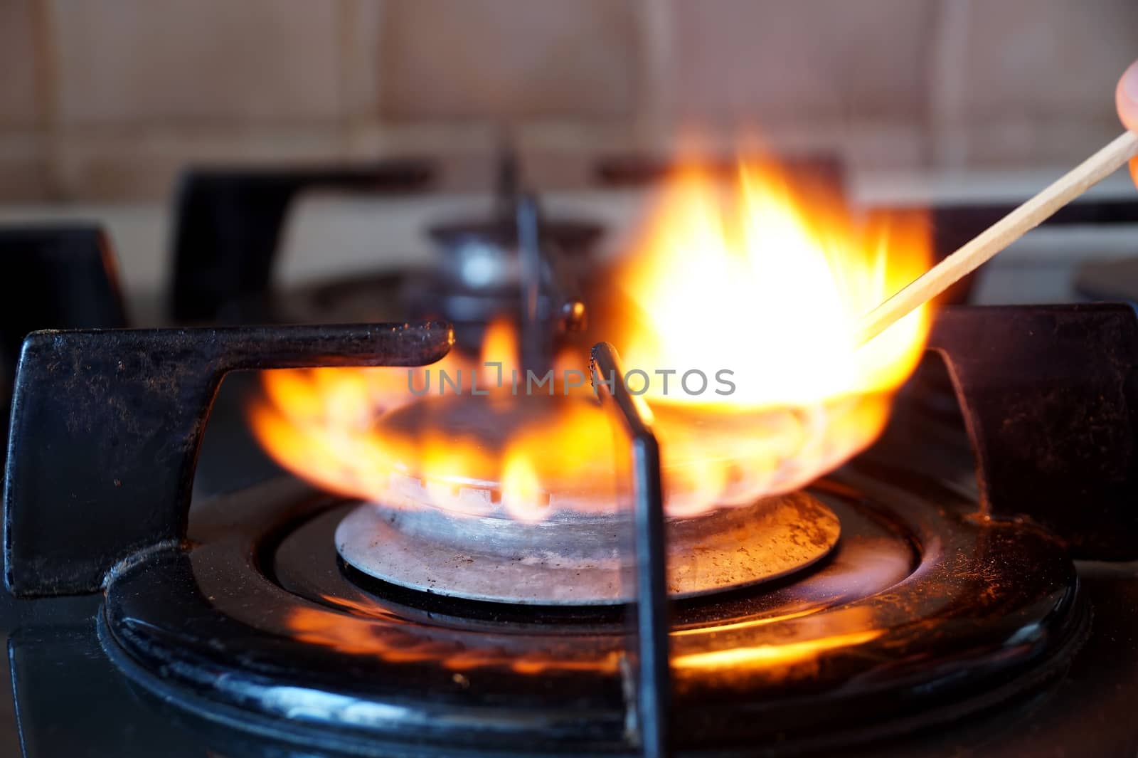 Ignition by a match of a gas ring on the stove