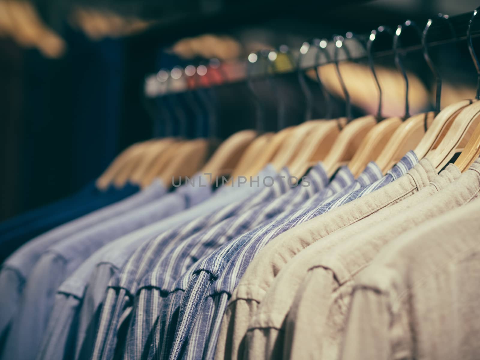 Close up view of man clothes hang in clothes store. Hangers with different male clothes. Copy space. Selective focus. Toned image