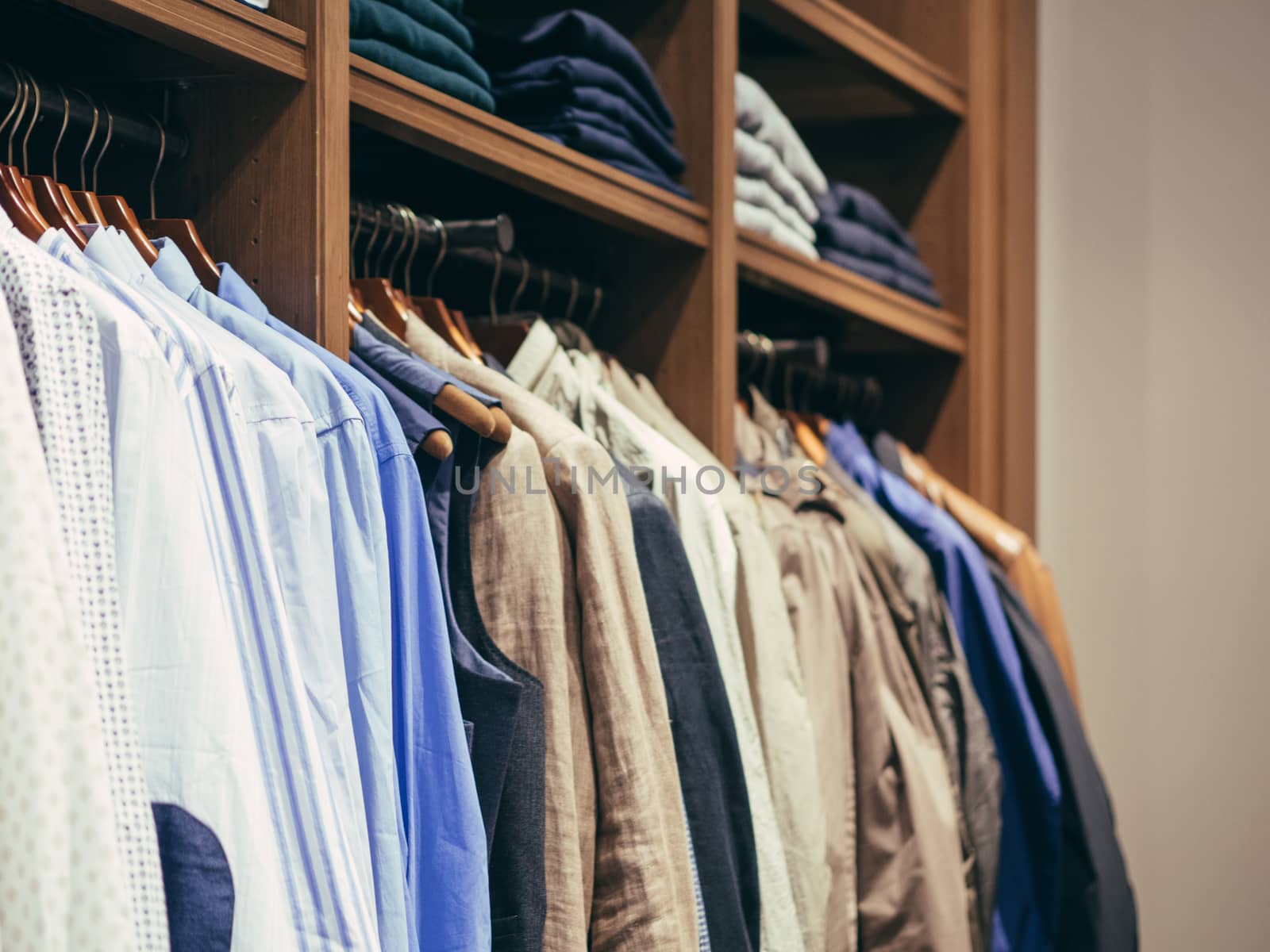 Close up view of man clothes hang in clothes store. Hangers with different male clothes. Copy space. Selective focus. Toned image